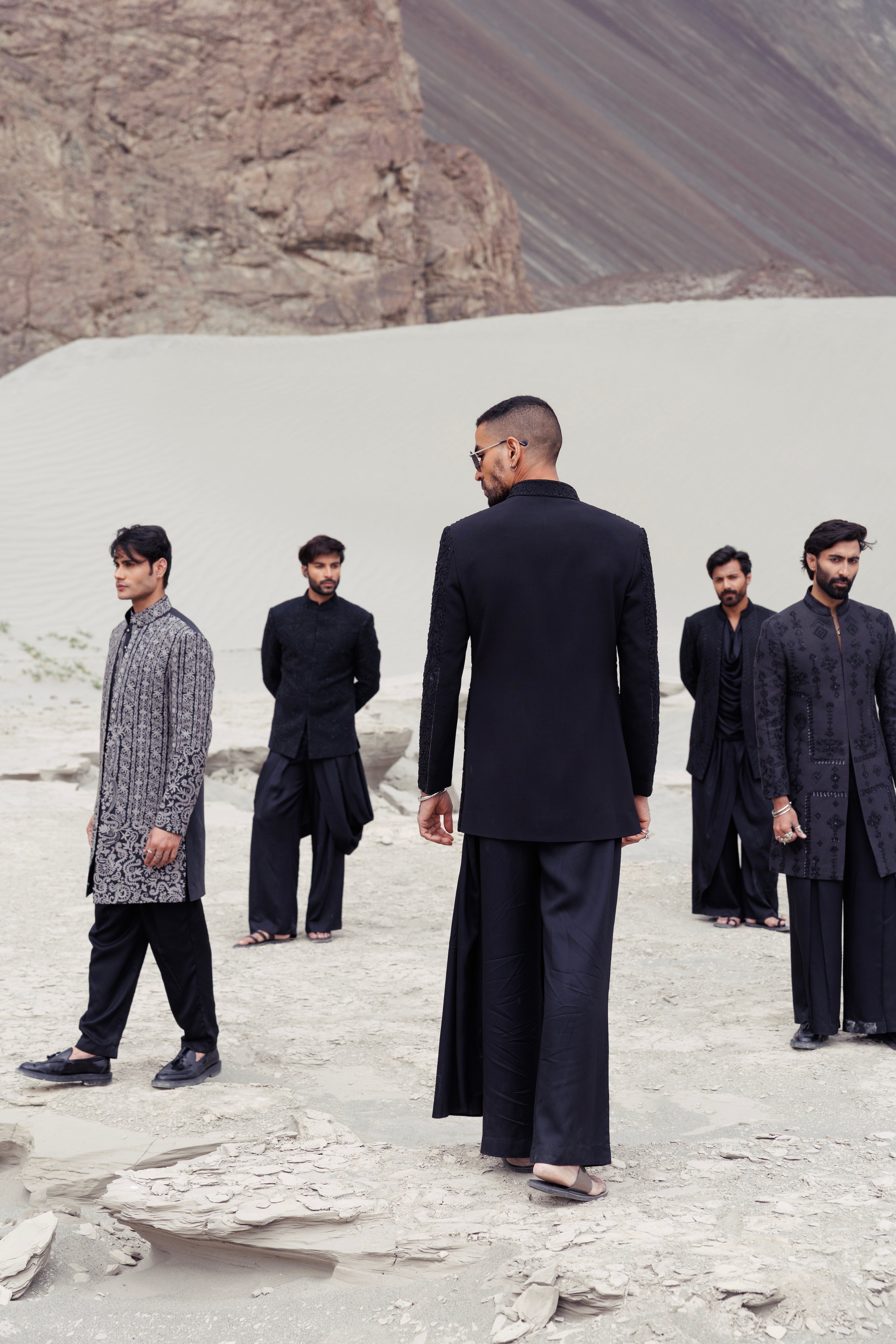 Black short indowestern jacket with front zipper and monotone hand-embroidery paired with a dhoti style plazo.