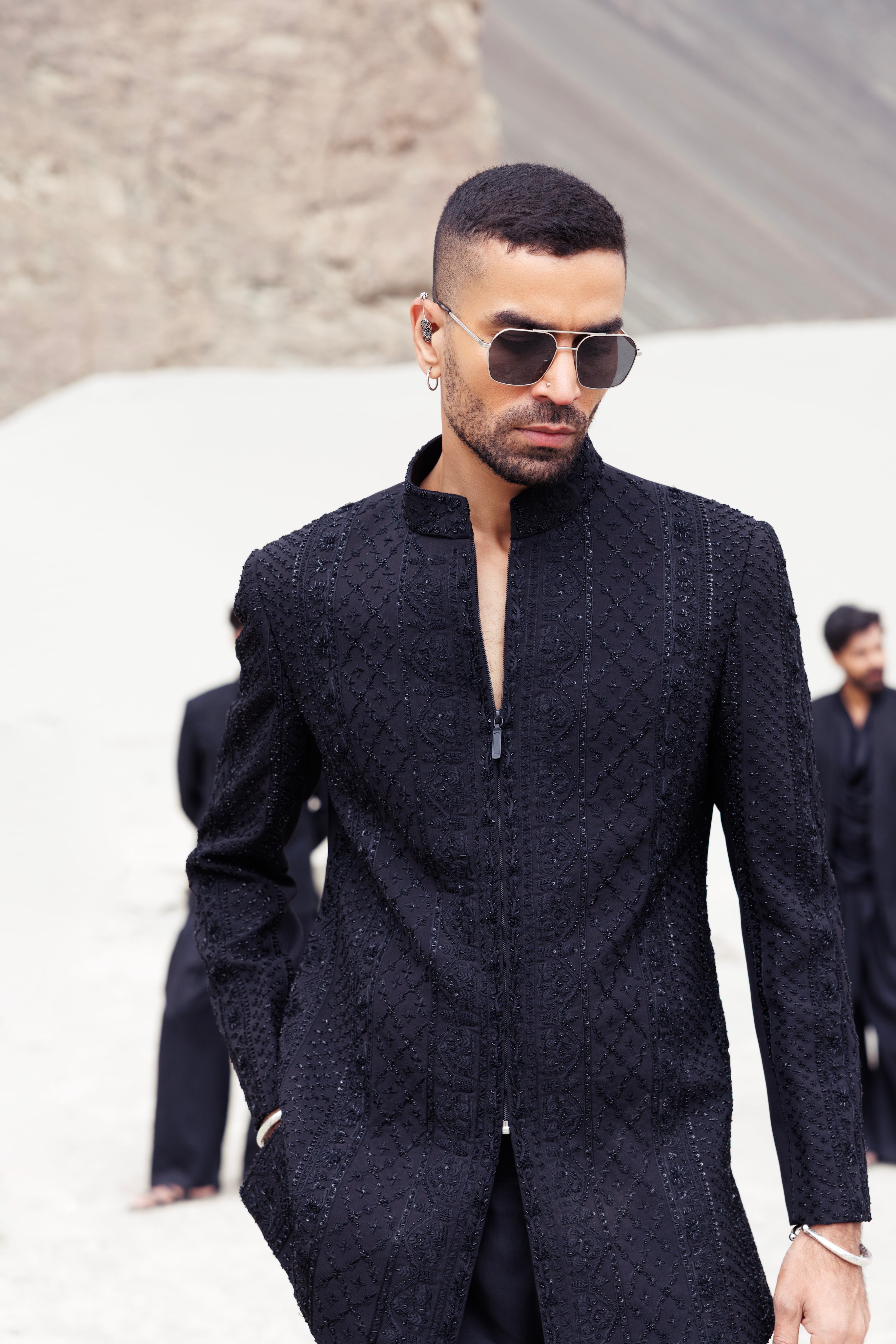 Black short indowestern jacket with front zipper and monotone hand-embroidery paired with a dhoti style plazo.