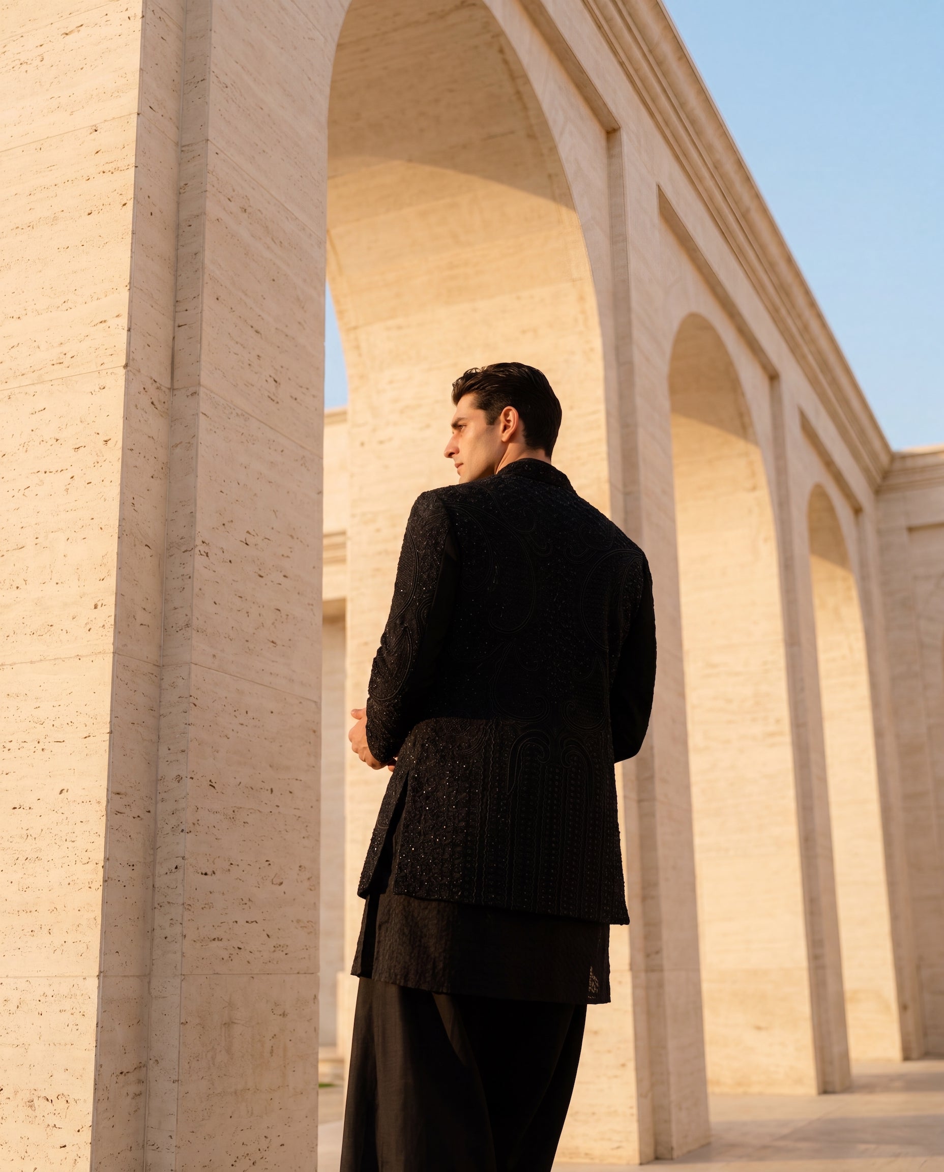 Black textured knit Indo-Western jacket with monotone embroidery, paired with a Banarasi silk kurta and knit palazzo.