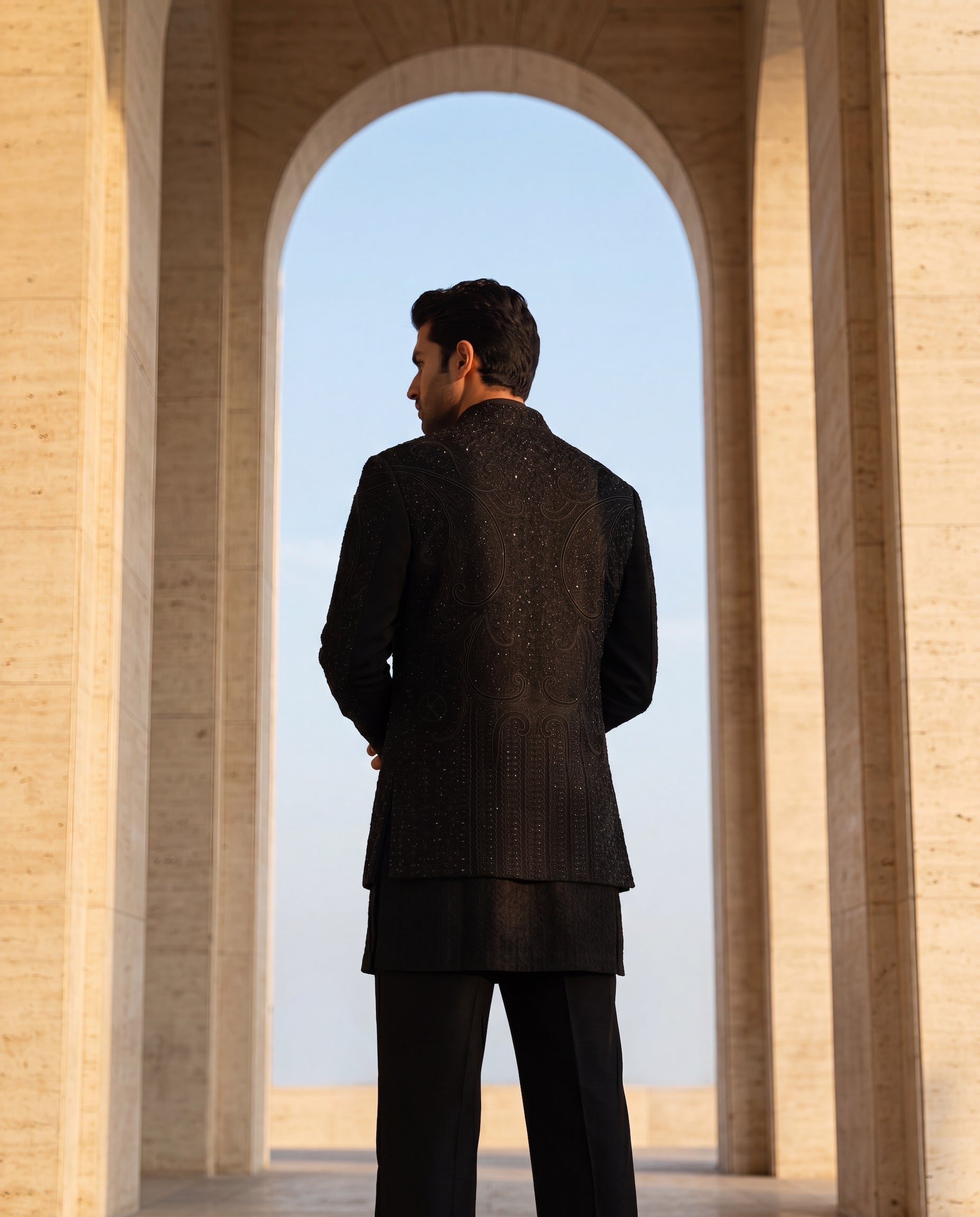 Black textured knit Indo-Western jacket with monotone embroidery, paired with a Banarasi silk kurta and knit palazzo.