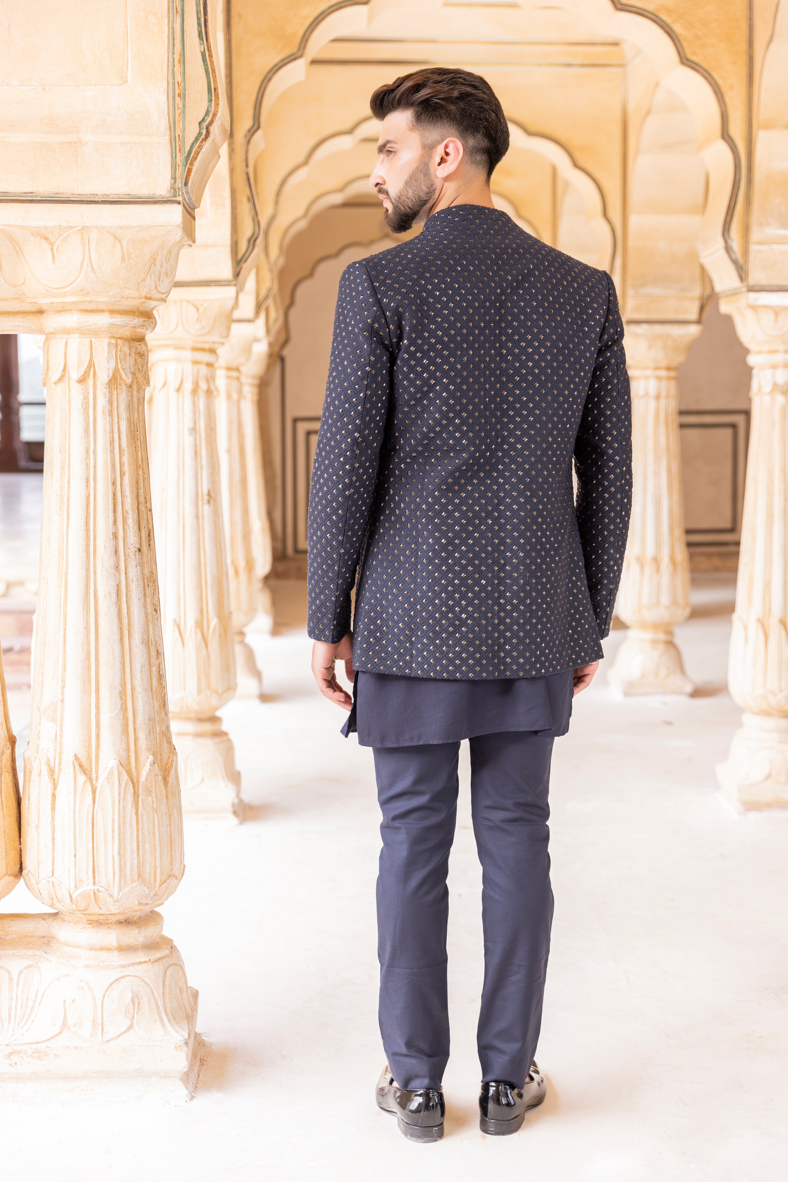 Navy Blue front open indowestern jacket embellished with metal work paired with a kurta and pants.