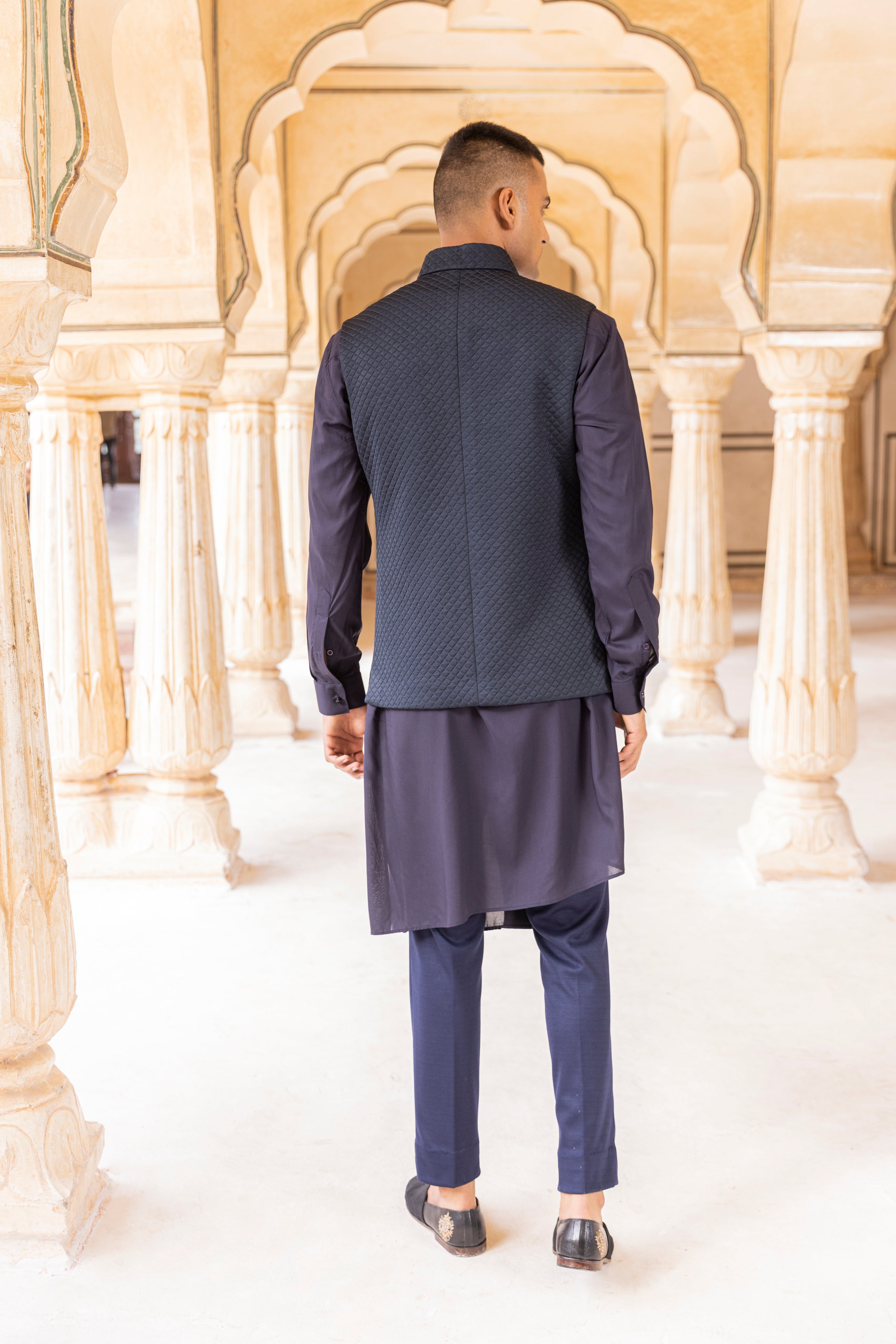 Quilted waistcoat embellished with Dragon motif using zari embroidery paired with kurta and aligadhi.