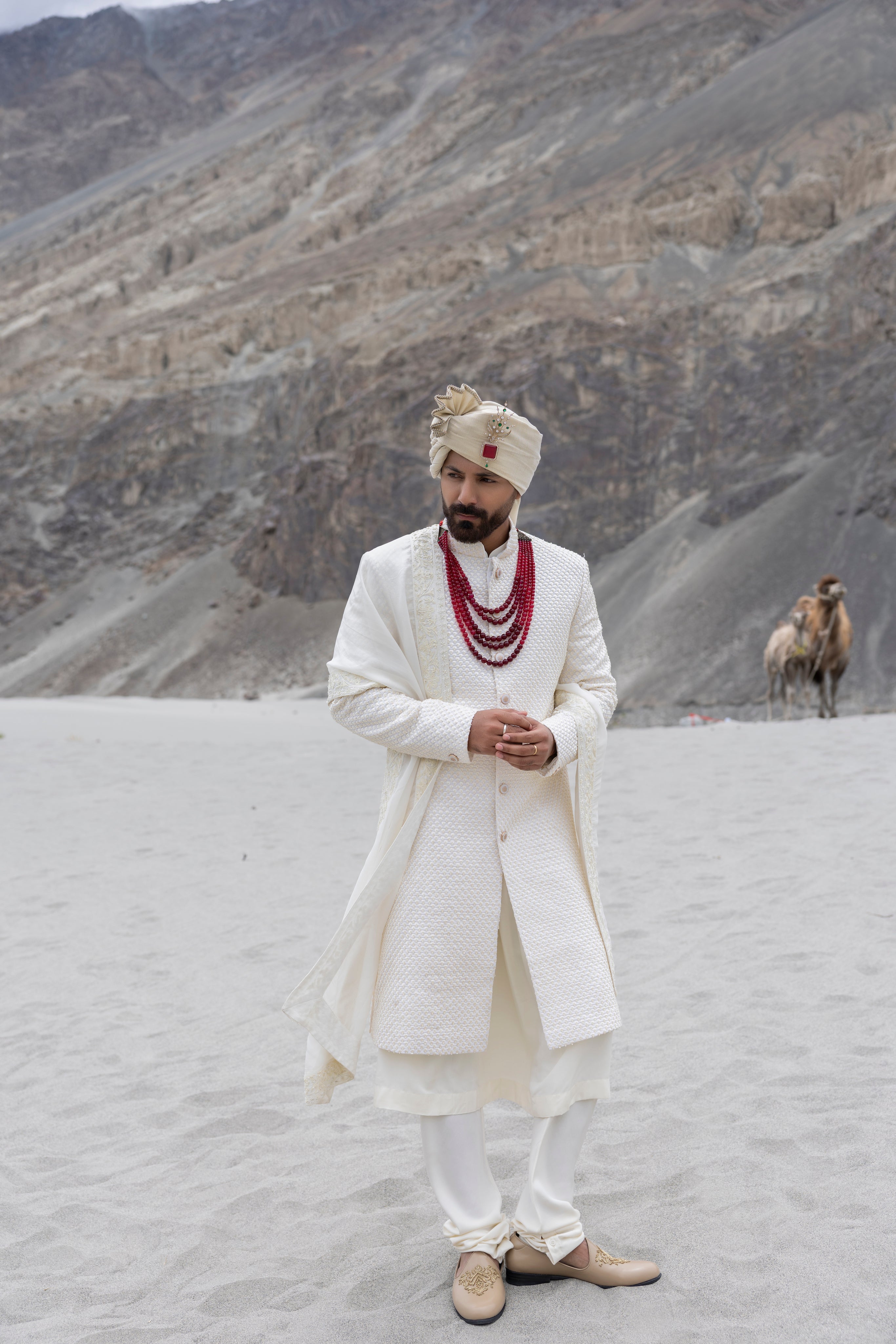 Ivory poly crepe sherwani with intricate hand-embroidery paired with a modal kurta pyjama & an organza stole.