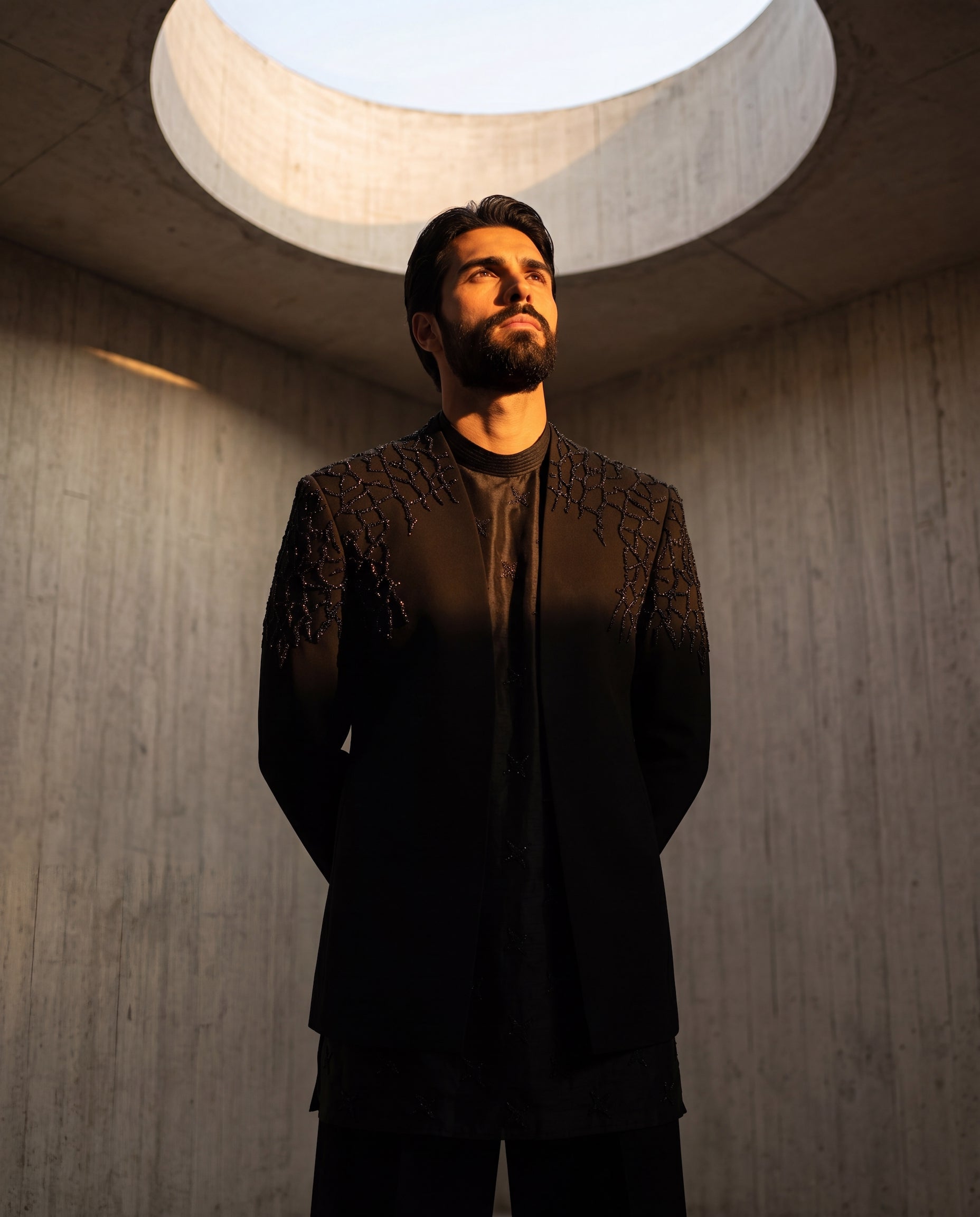 Textured knit Indo-Western jacket with tonal detailing, paired with a raw silk kurta and matching knit pants.