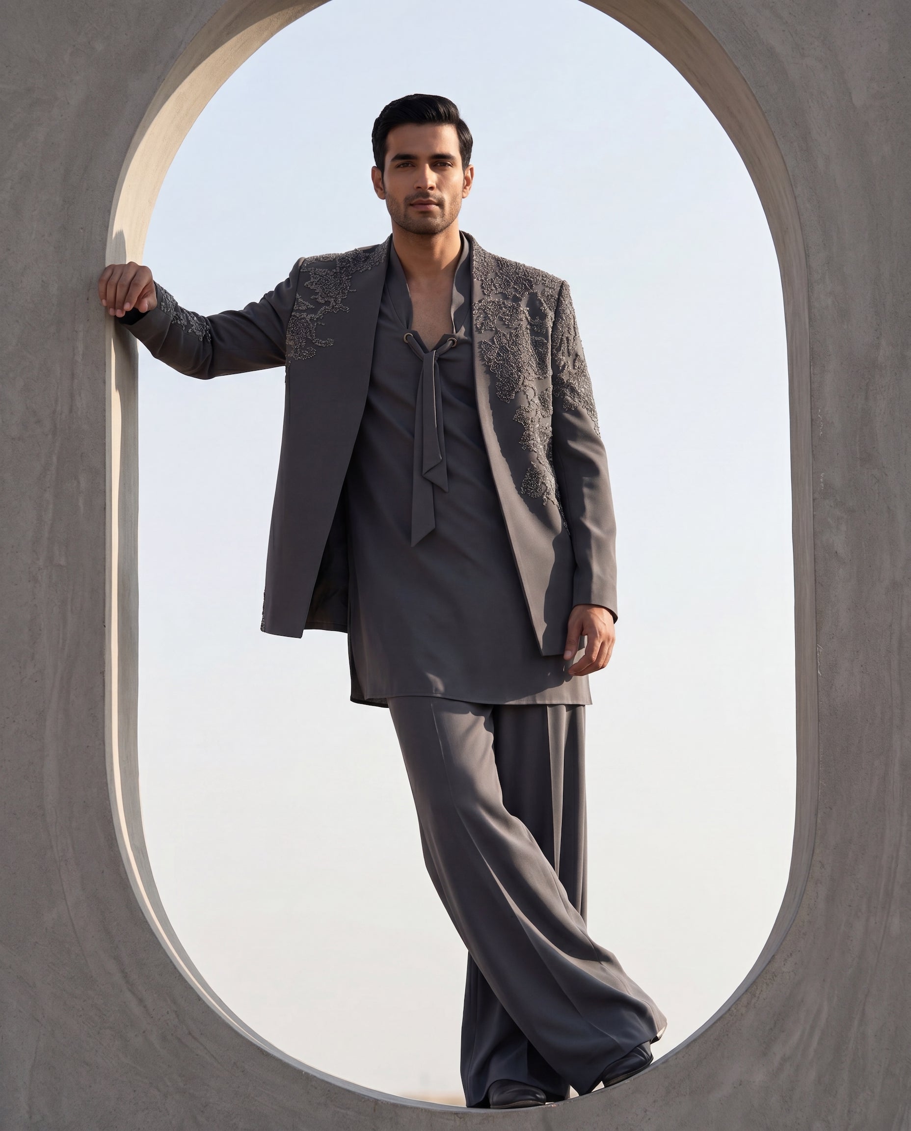Grey knit Indo-Western jacket with metallic embroidery, paired with a knit kurta and matching palazzo.