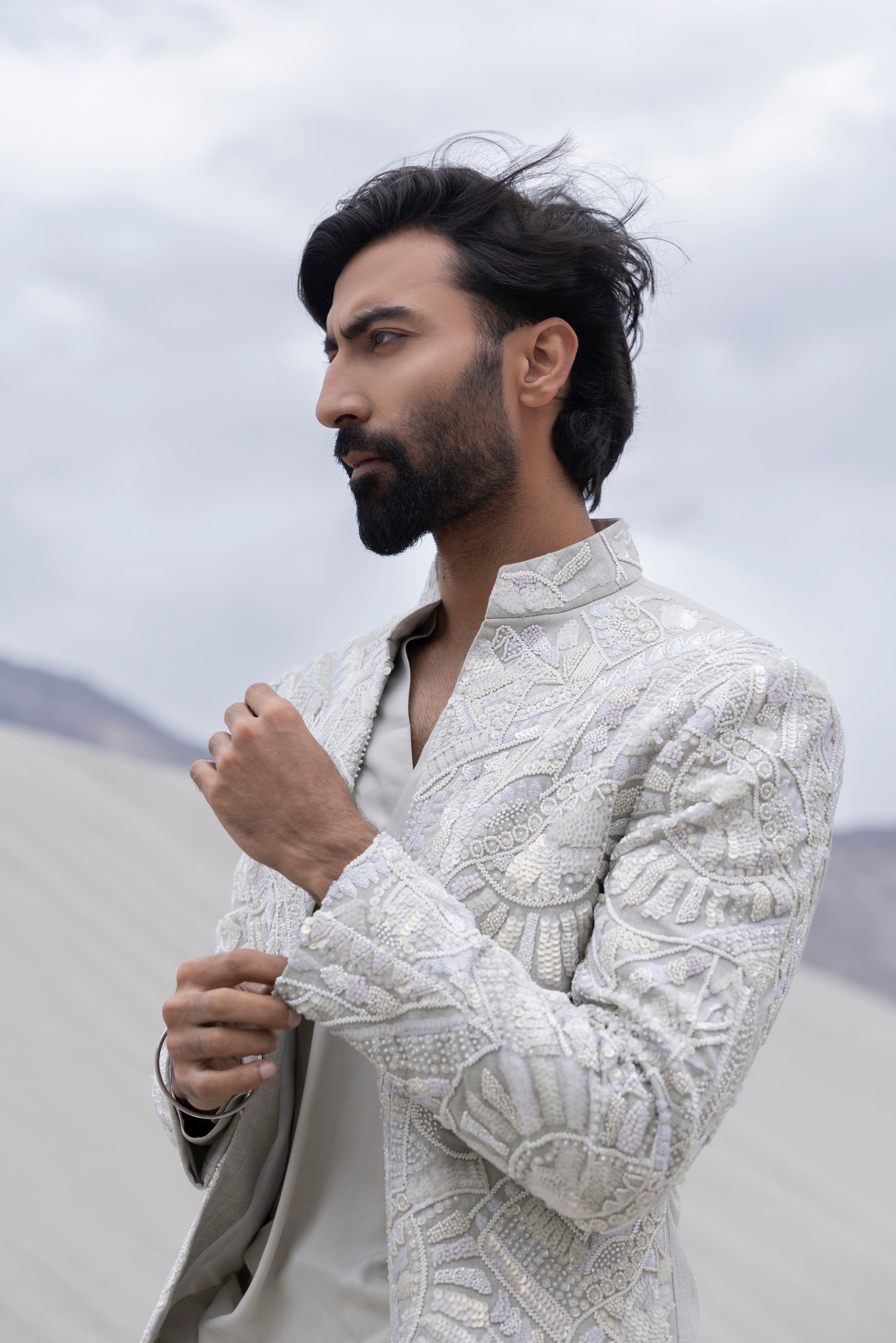 Grey font open hand-embroidered  indowestern jacket paired with a v-neck short  kurta and pants.