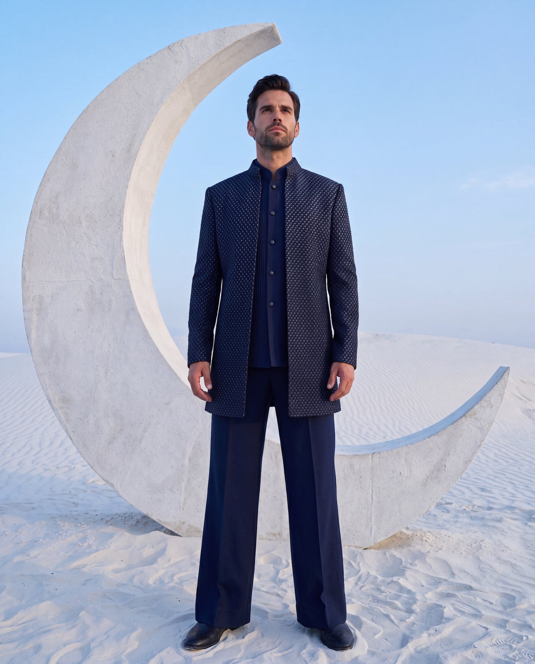 Navy blue crepe Indo-Western jacket with monotone embroidery paired with a matka silk waistcoat and knit pants.