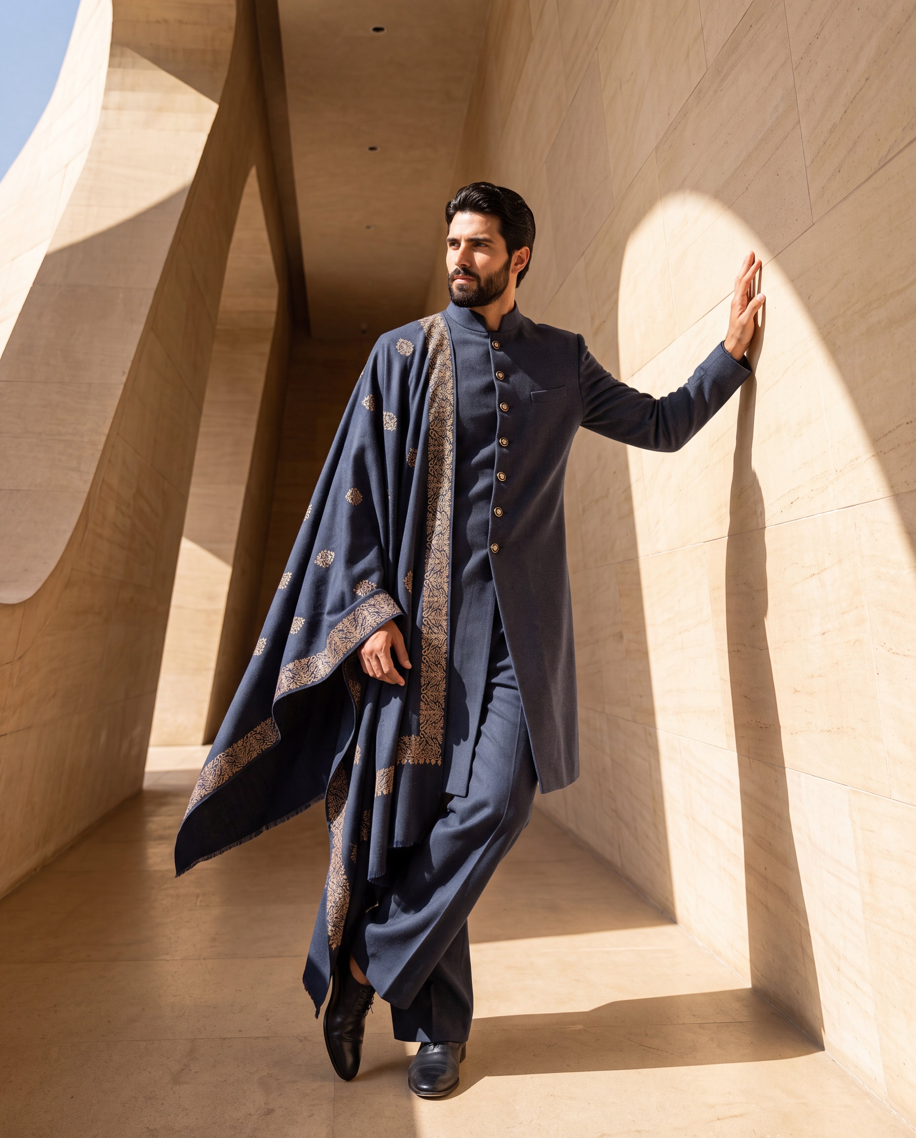 Navy blue Pashmina sherwani featuring contrast buttons along the front, paired with matching pashmina pants and a pashmina stole embellished with a hand-embroidered border & motifs all over.