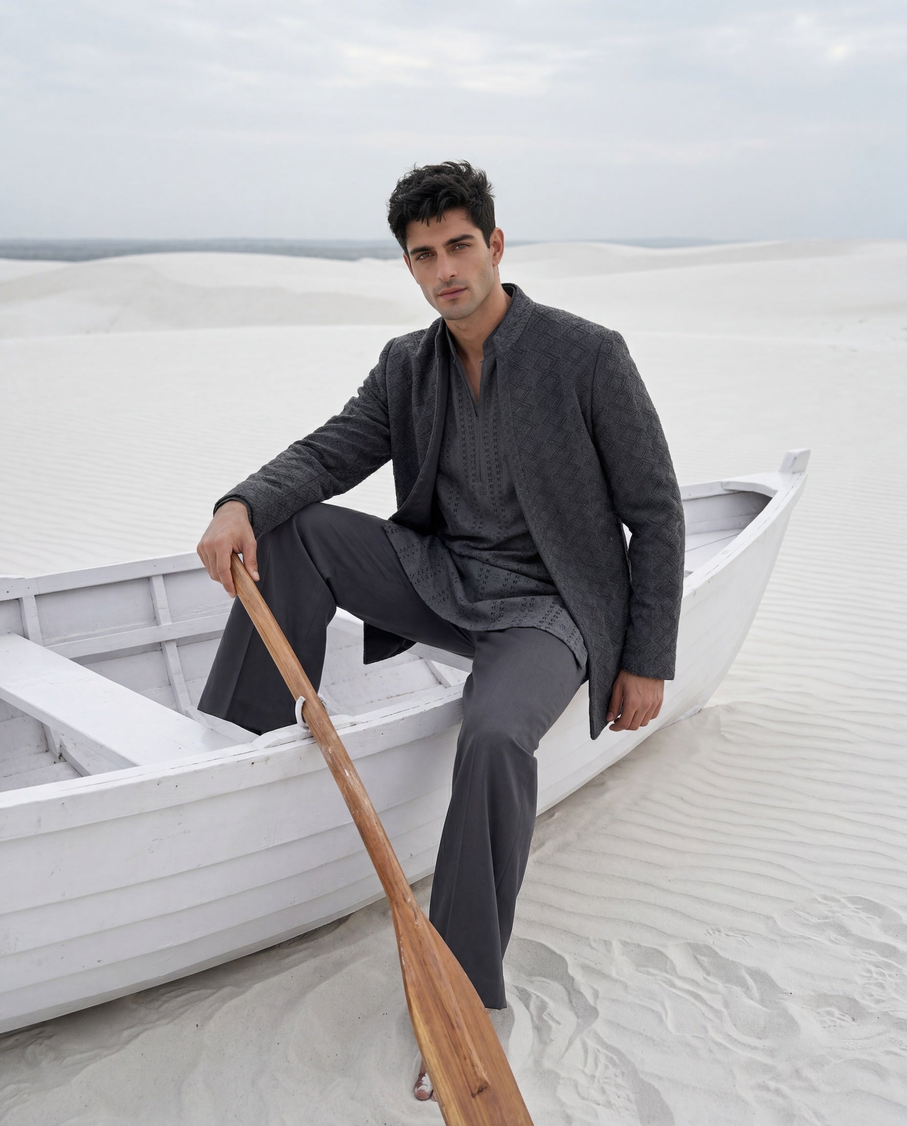 Dark grey crochet Indo-Western jacket with embroidery detailing, paired with a matching crochet kurta and knit pants.