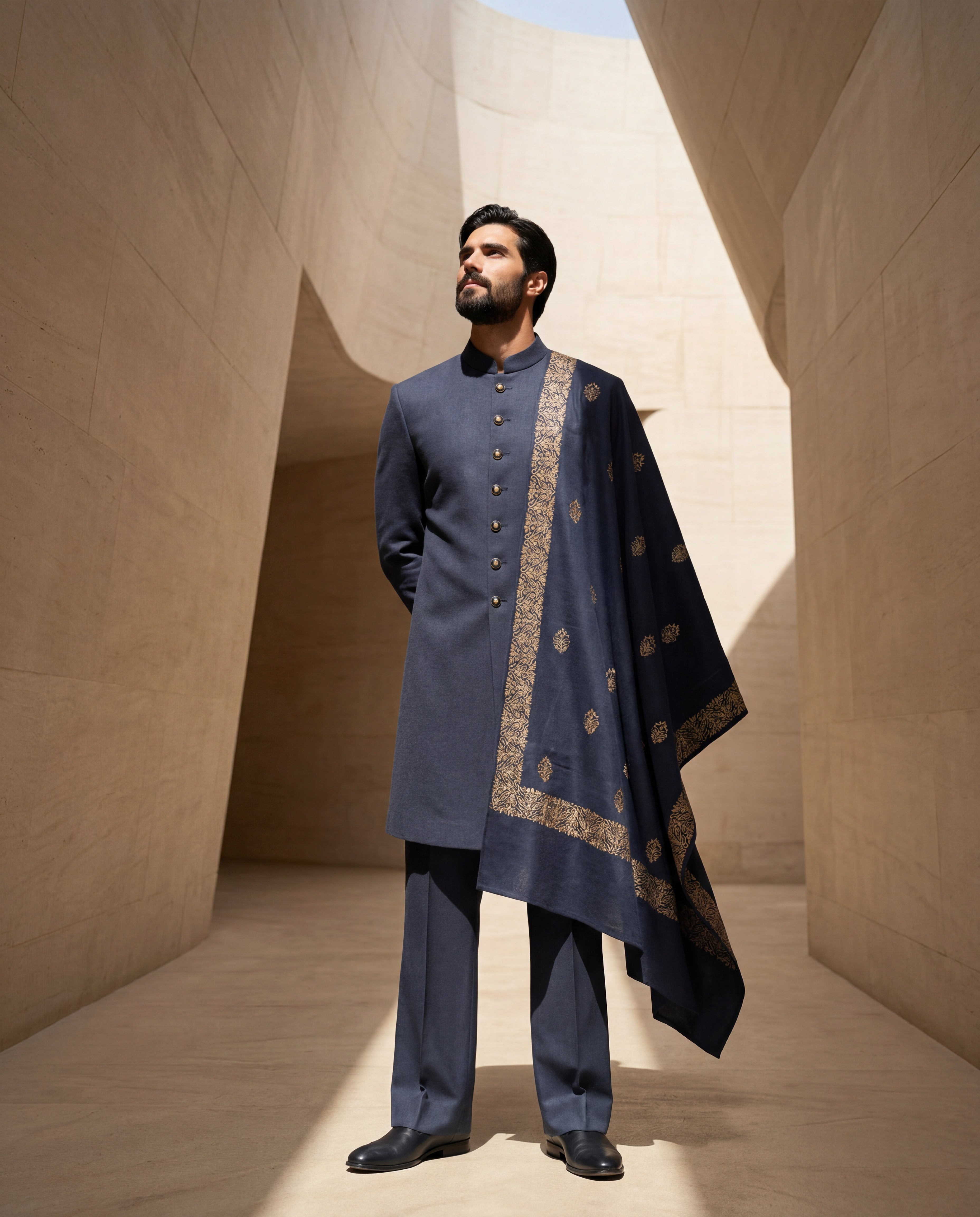 Navy blue Pashmina sherwani featuring contrast buttons along the front, paired with matching pashmina pants and a pashmina stole embellished with a hand-embroidered border & motifs all over.