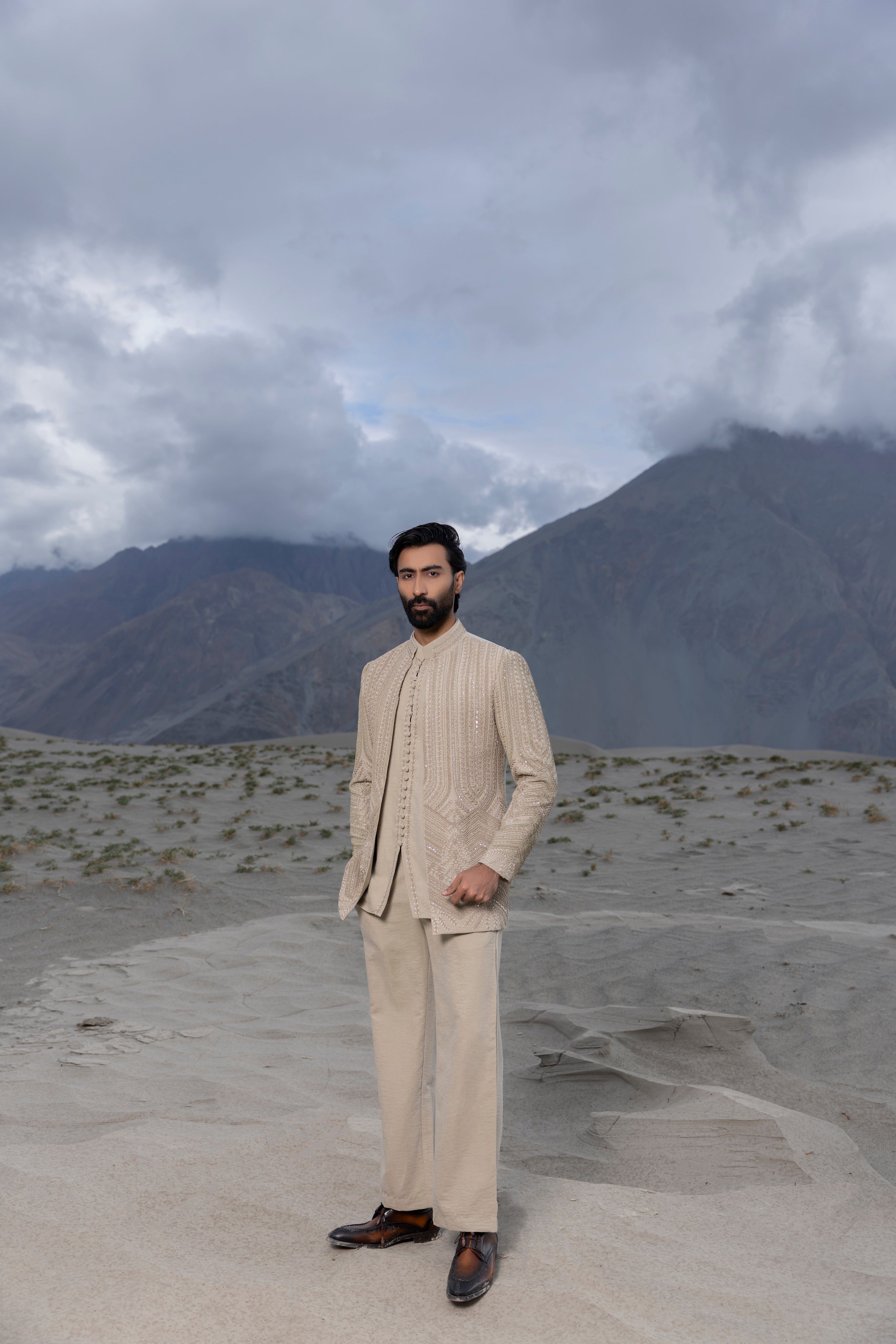 Beige front open short indowestern jacket with monotone hand-embroidery paired with a short loop button  kurta and pants.