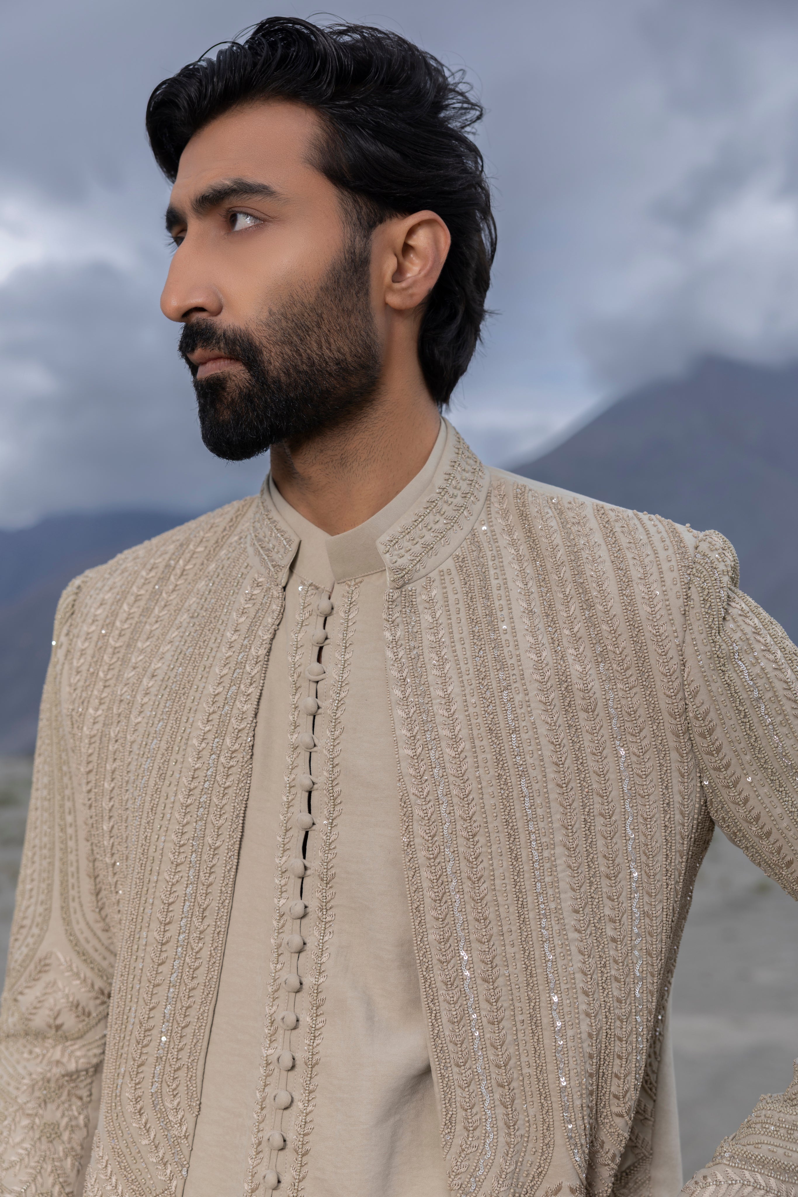Beige front open short indowestern jacket with monotone hand-embroidery paired with a short loop button  kurta and pants.
