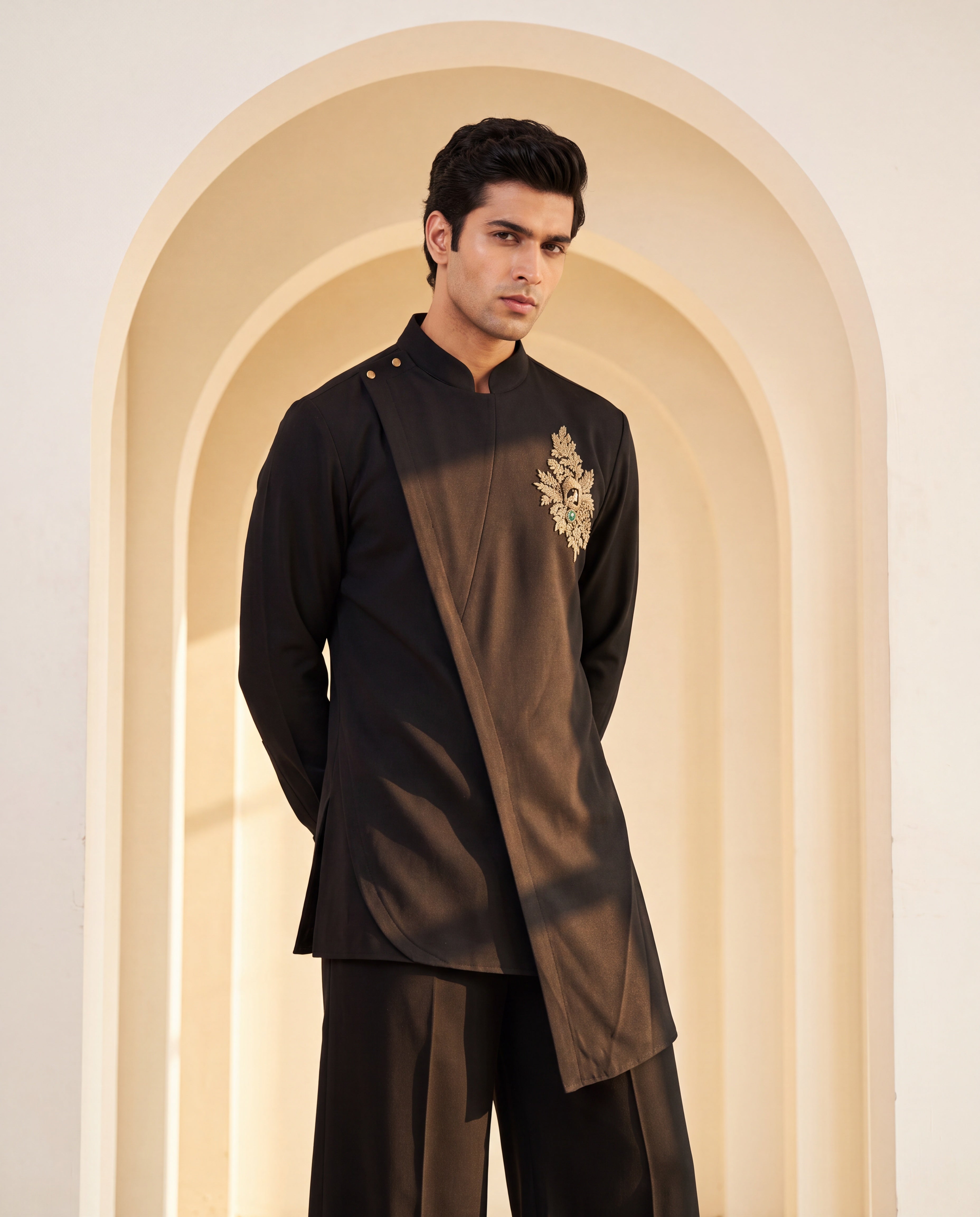 Black knit kurta with gold brooch with embroidery & asymmetric cut detailing, paired with matching knit palazzo.