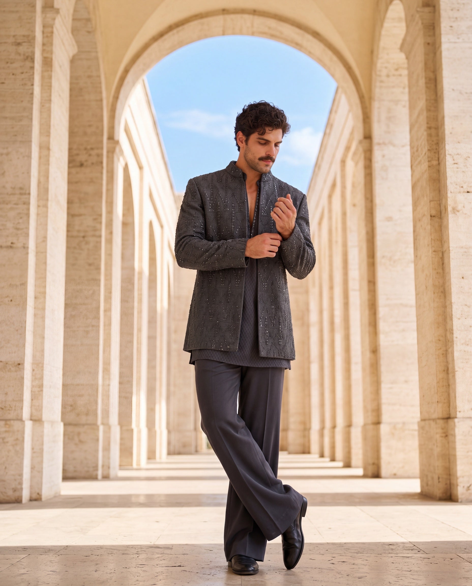 Dark grey crochet Indo-Western jacket with tonal embroidery, paired with a matching crochet kurta and pants.