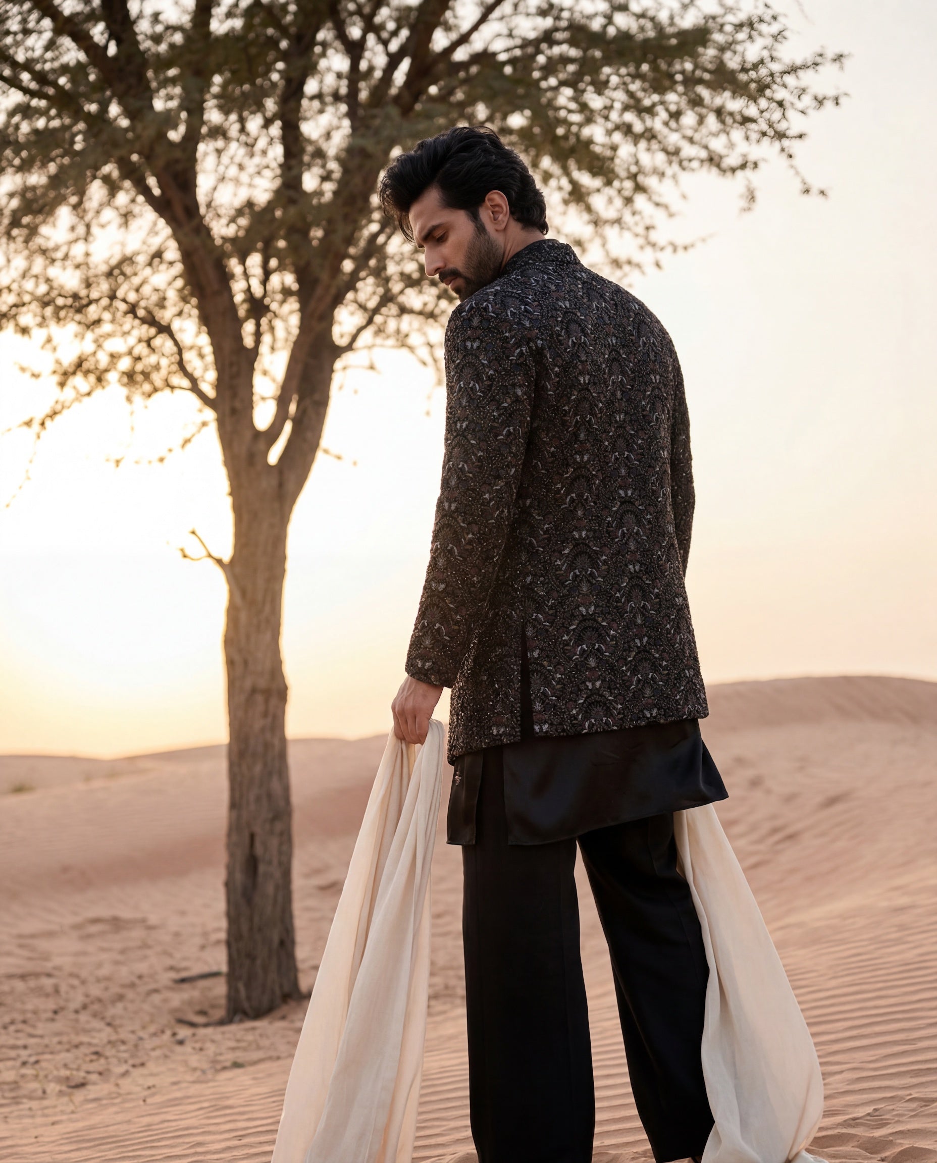 Black velvet Indo-Western jacket with intricate multi-coloured hand-embroidered, paired with an embroidered knit kurta and matching palazzo.