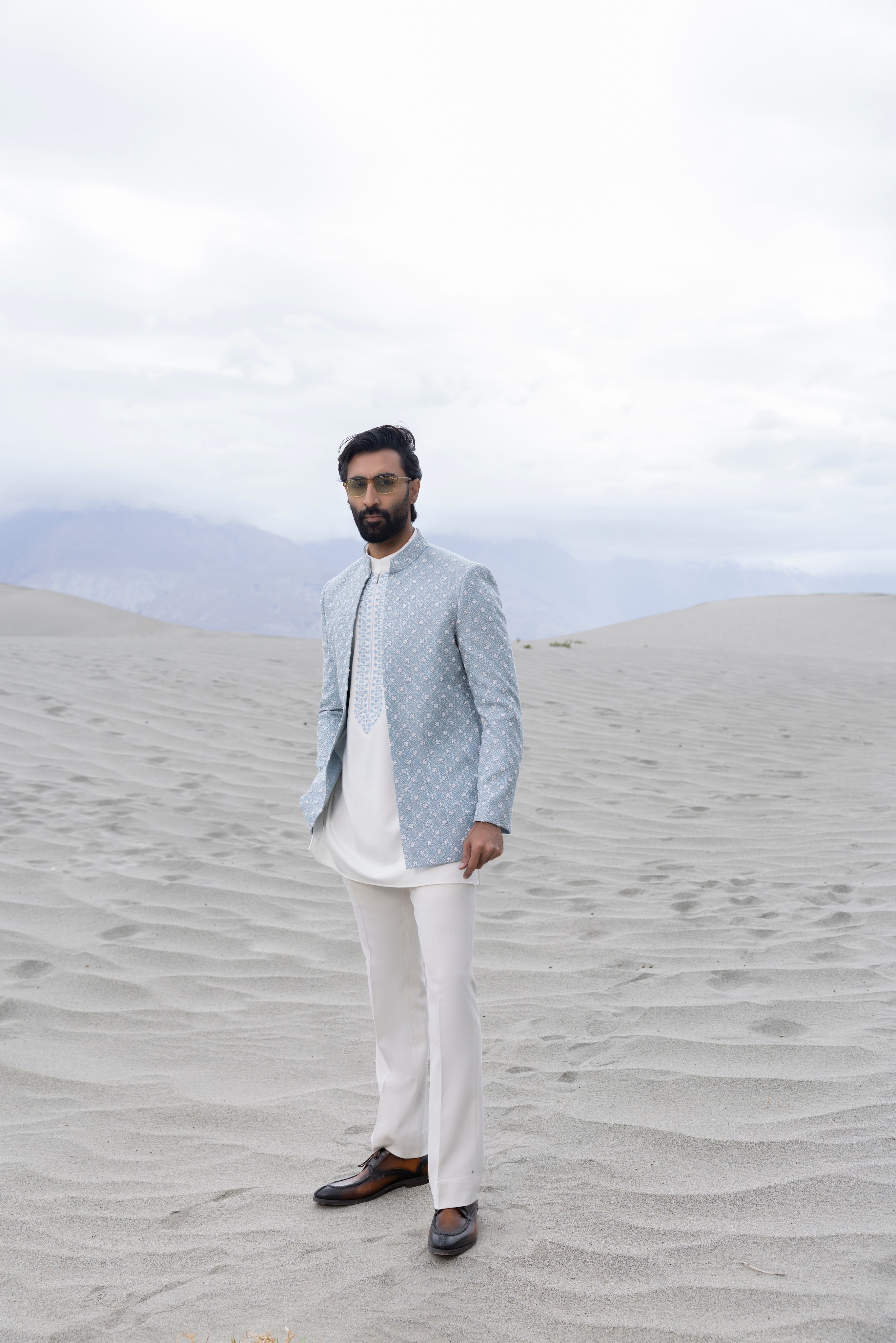 Sky Blue front open short indowestern jacket ivory hand-embroidery paired with an ivory embroidered  short kurta  and pants.