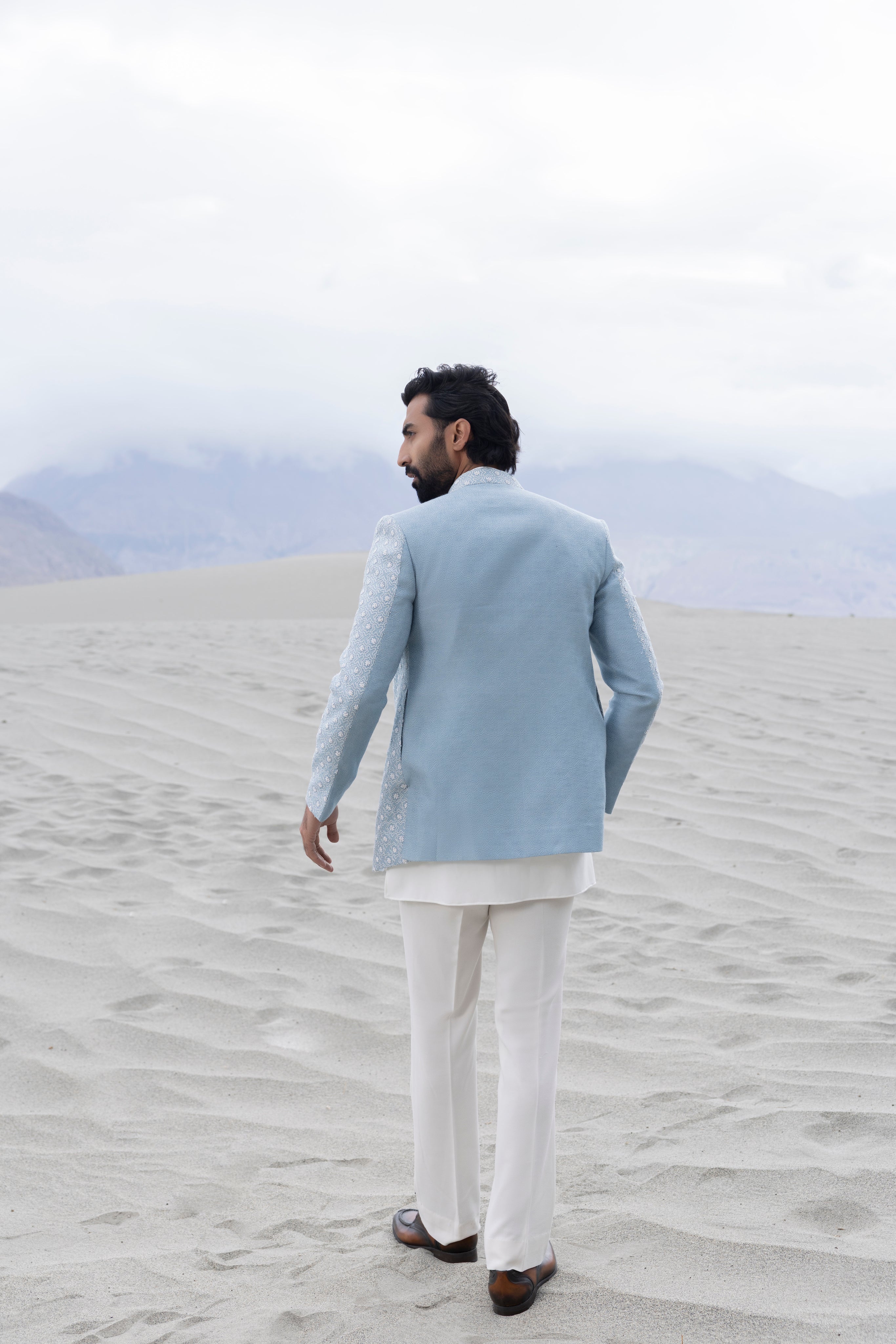 Sky Blue front open short indowestern jacket ivory hand-embroidery paired with an ivory embroidered  short kurta  and pants.