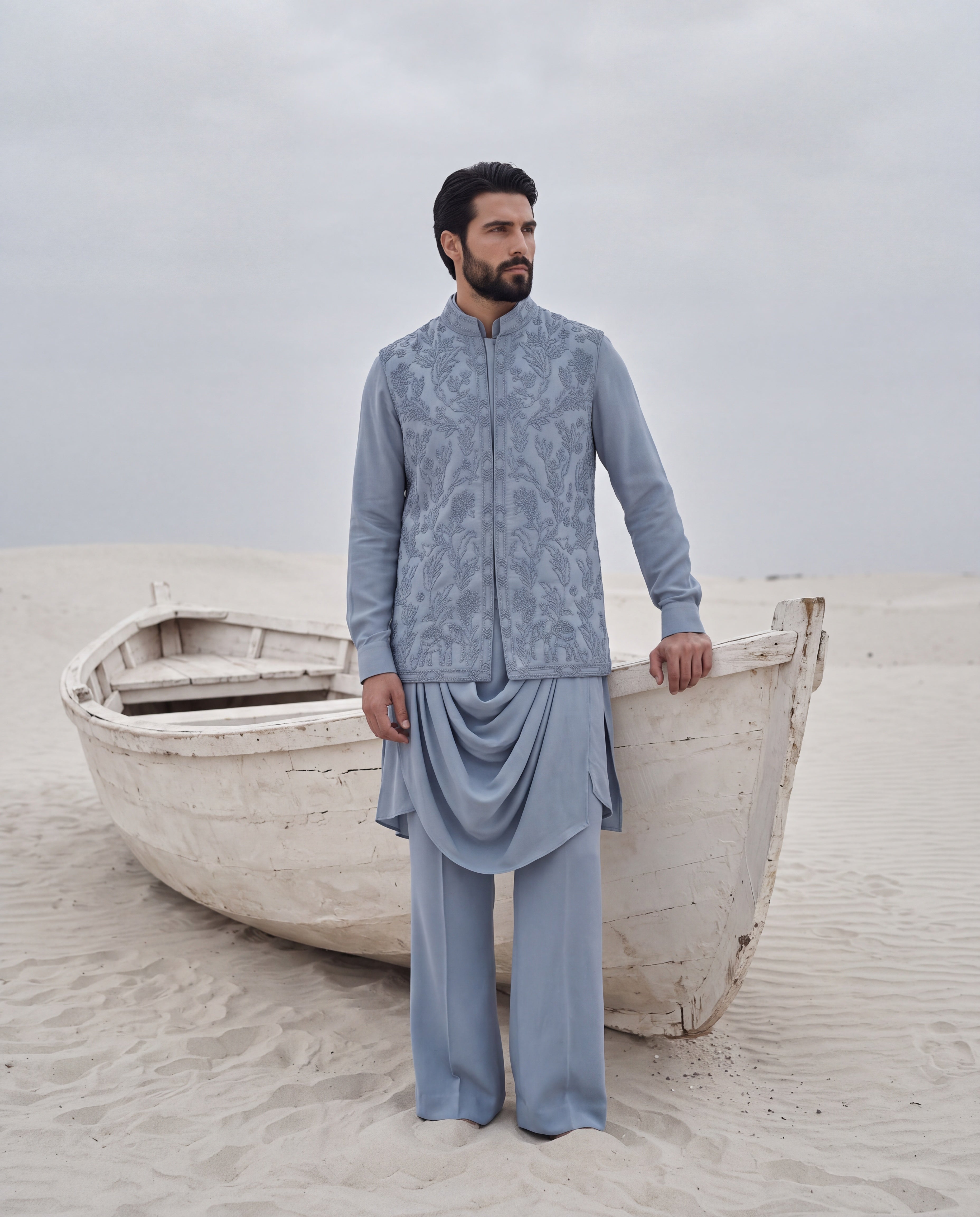 Powdered blue waistcoat with monotone hand embroidery detailing, paired with a draped knit kurta and matching plazzo pants.
