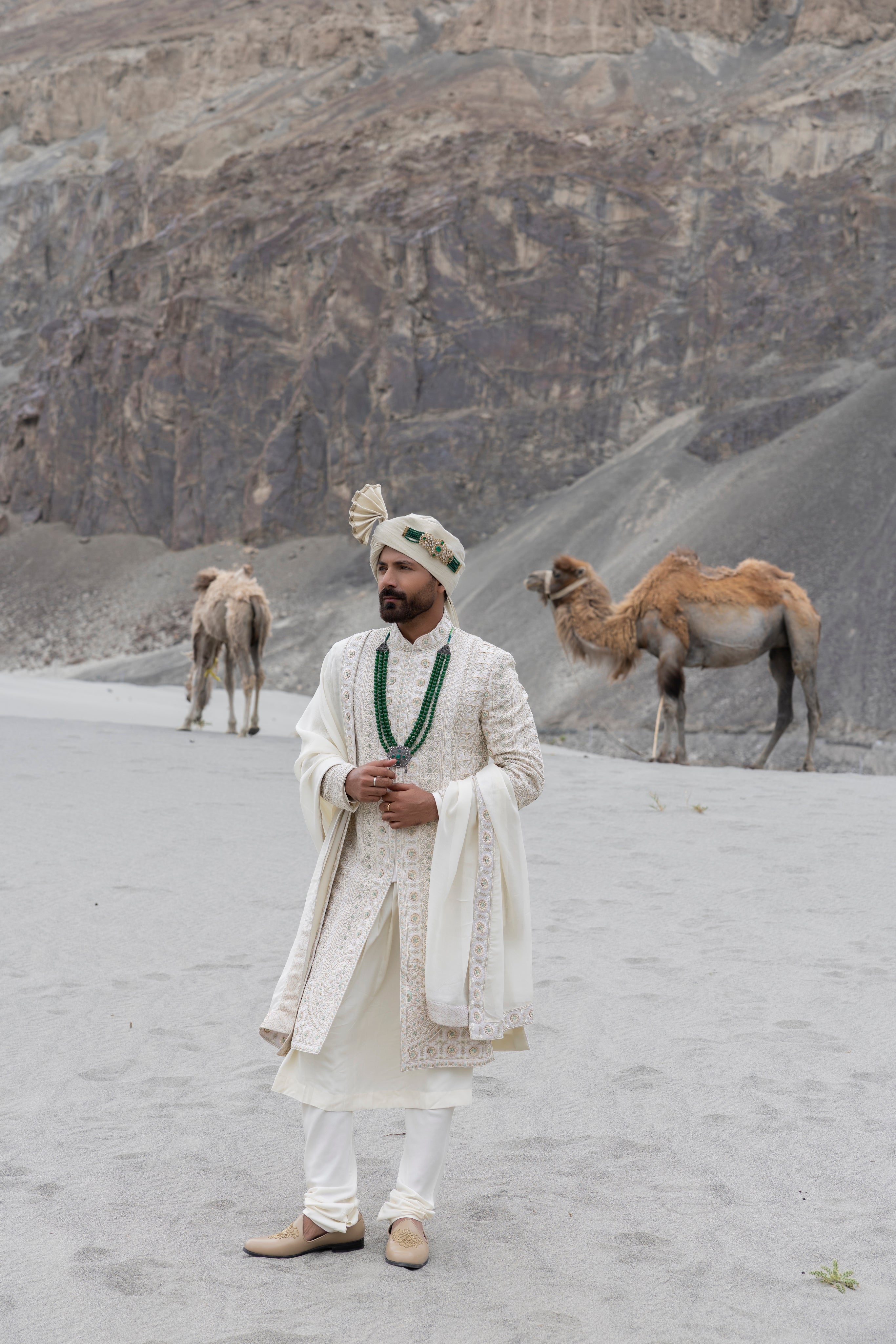 Cream raw silk sherwani with intricate hand-embroidery paired with a modal kurta pyjama & an organza stole.