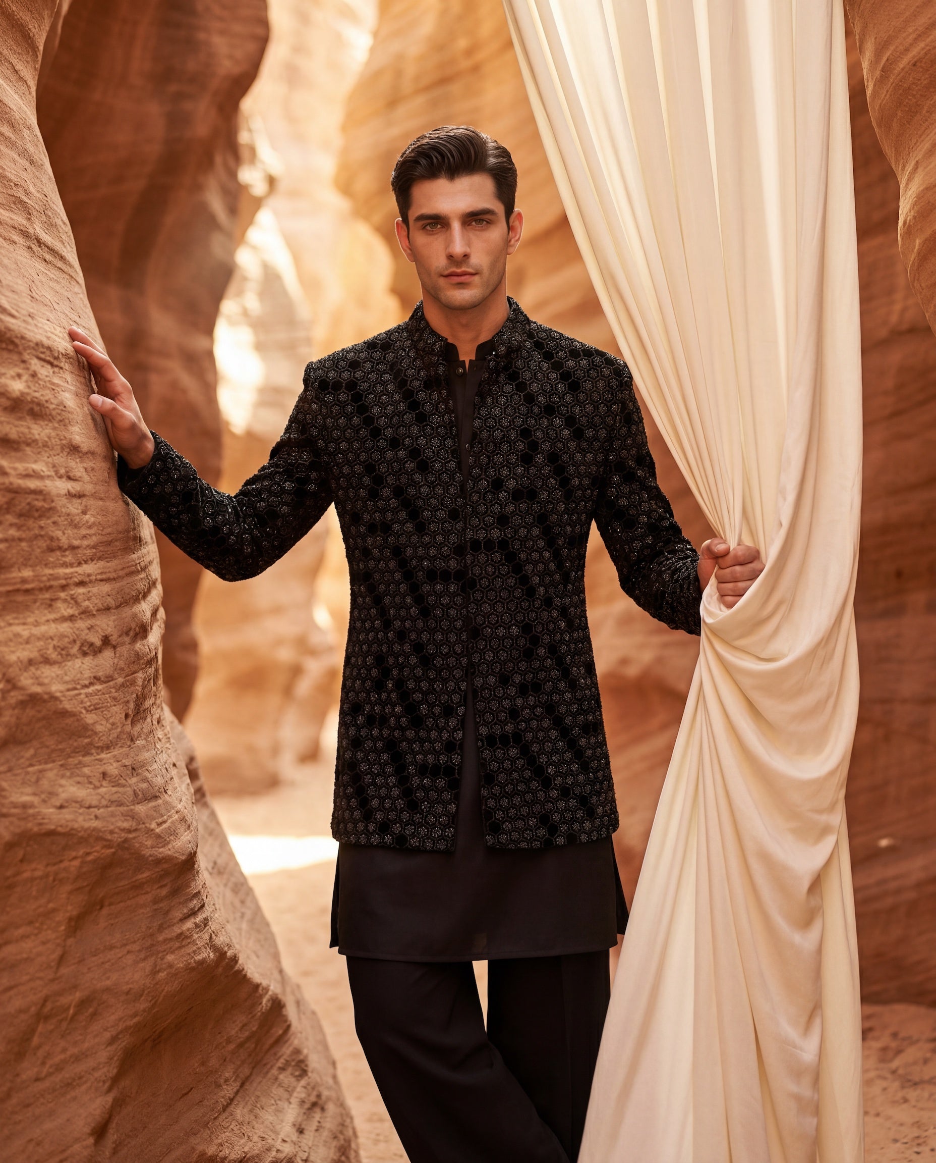 Black velvet Indo-Western jacket with honey-comb pattern embroidery detailing, paired with a cotton modal kurta and poly-wool pants.