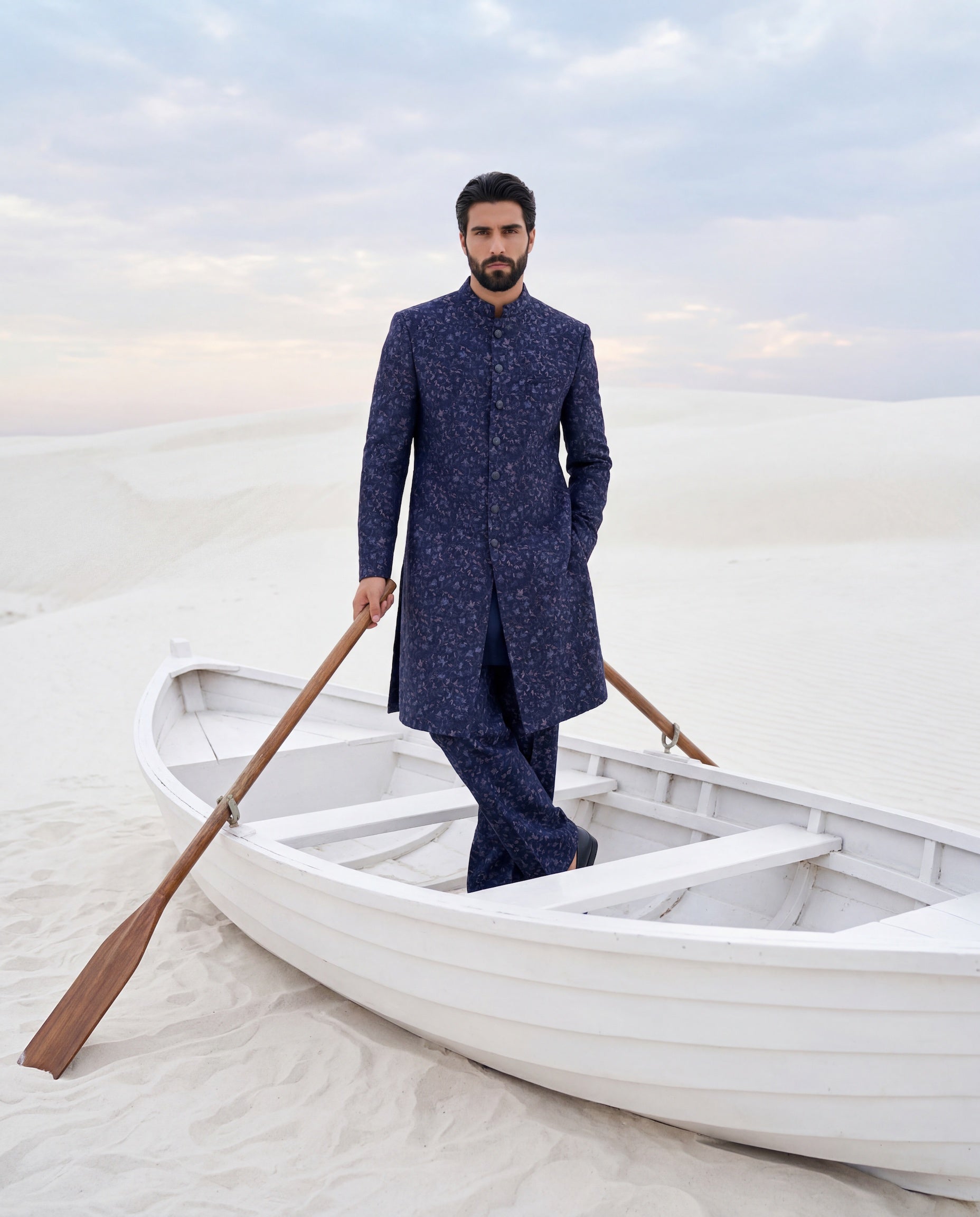 Navy blue Pashmina sherwani with intricate multi-coloured embroidery detailing, paired with matching knit pants.