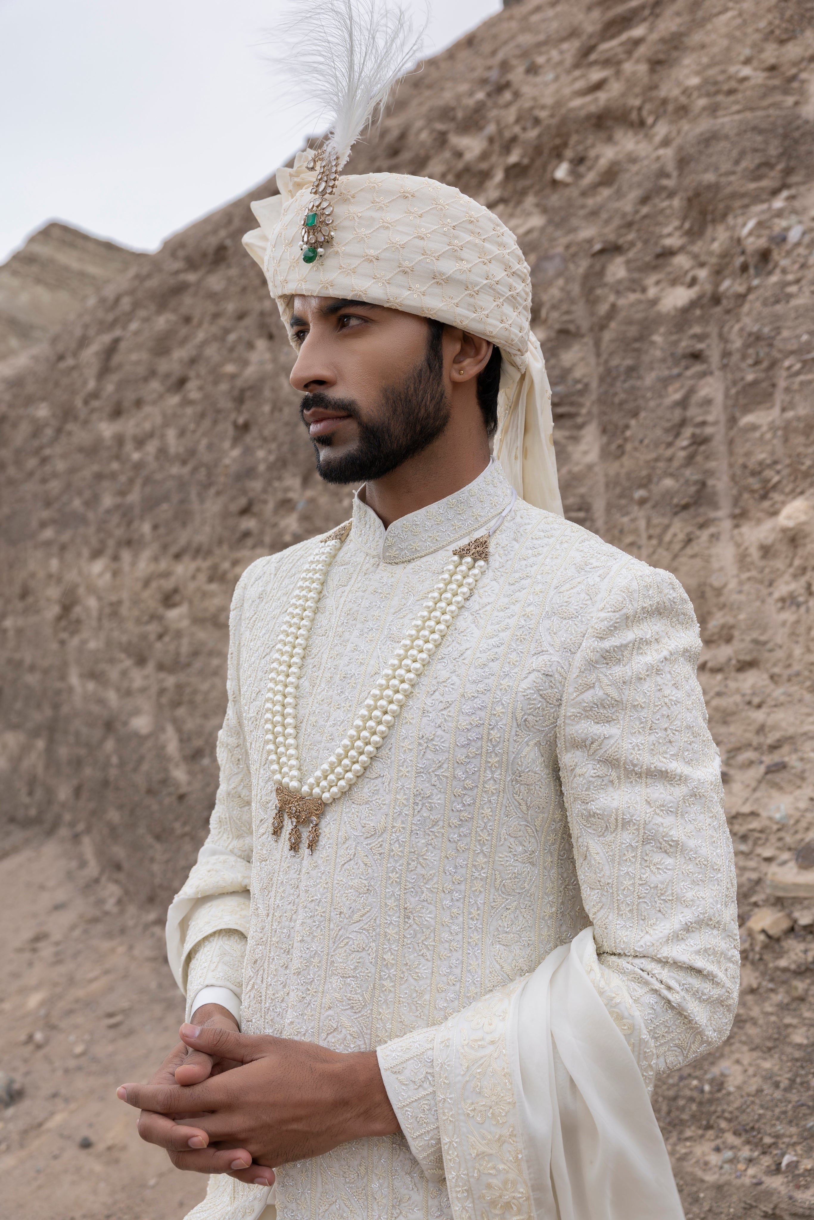 Cream textured poly knit sherwani with intricate hand-embroidery paired with a modal kurta pyjama & an organza stole.