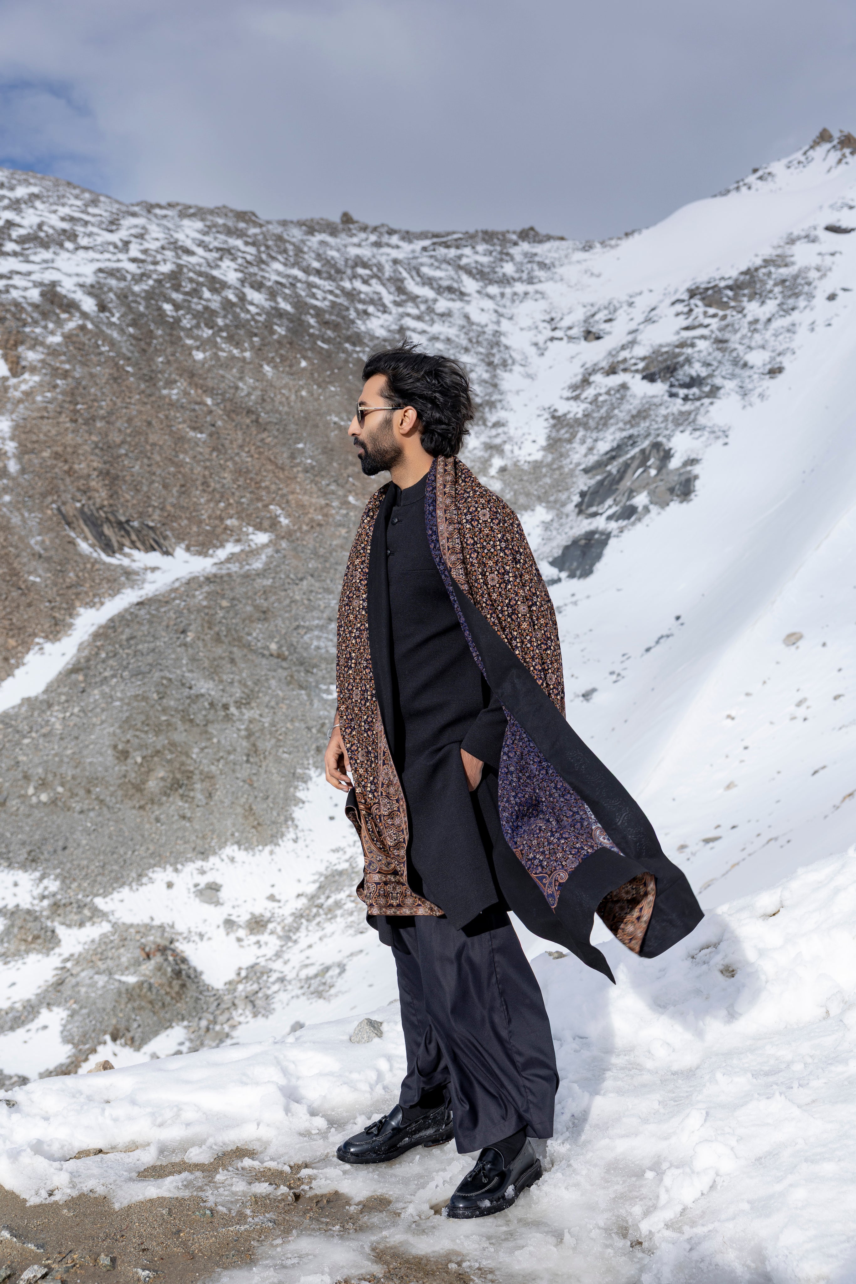 Black textured knit long indowestern jacket paired with a black plazo and a  geogrette stole with multi-colour embroidery.