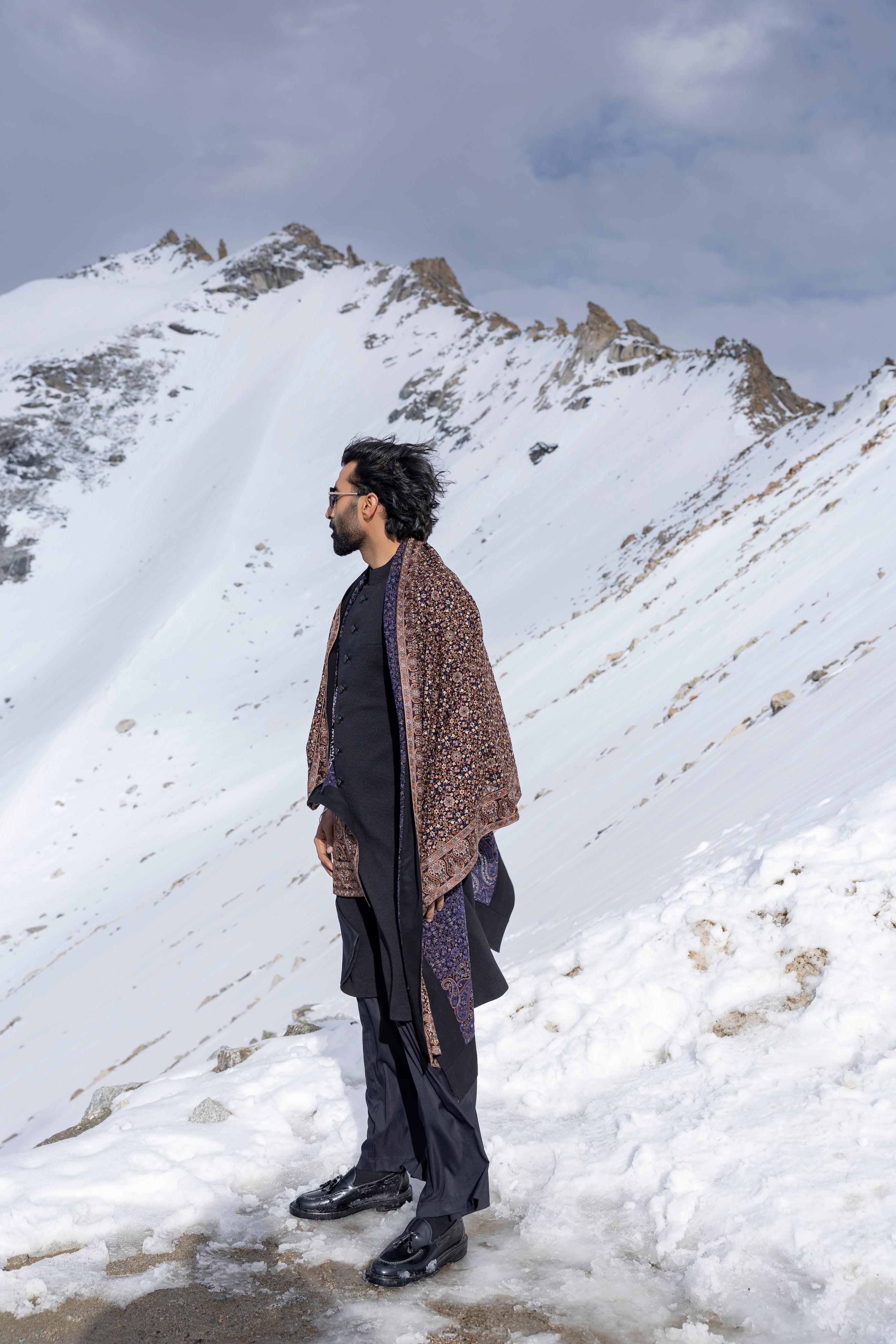Black textured knit long indowestern jacket paired with a black plazo and a  geogrette stole with multi-colour embroidery.