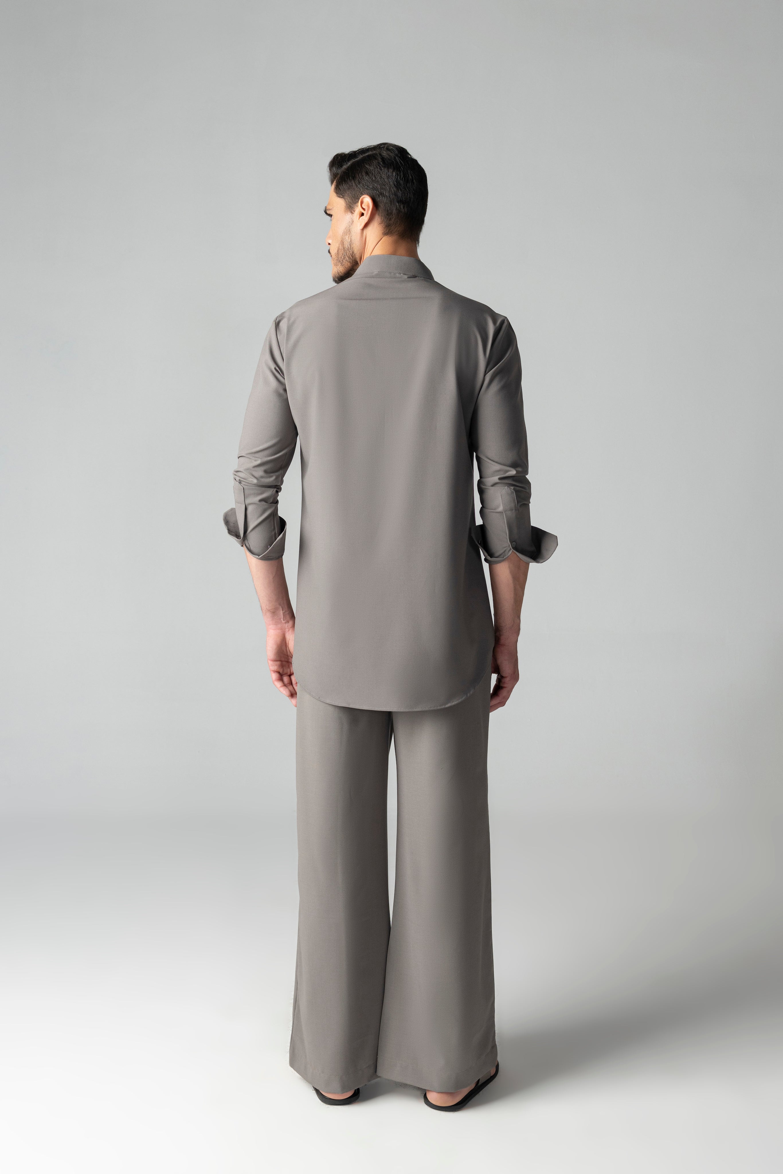 Mouse coloured short crepe kurta with thread embroidery on the waist & patch pocket detailing, paired with a matching plazzo