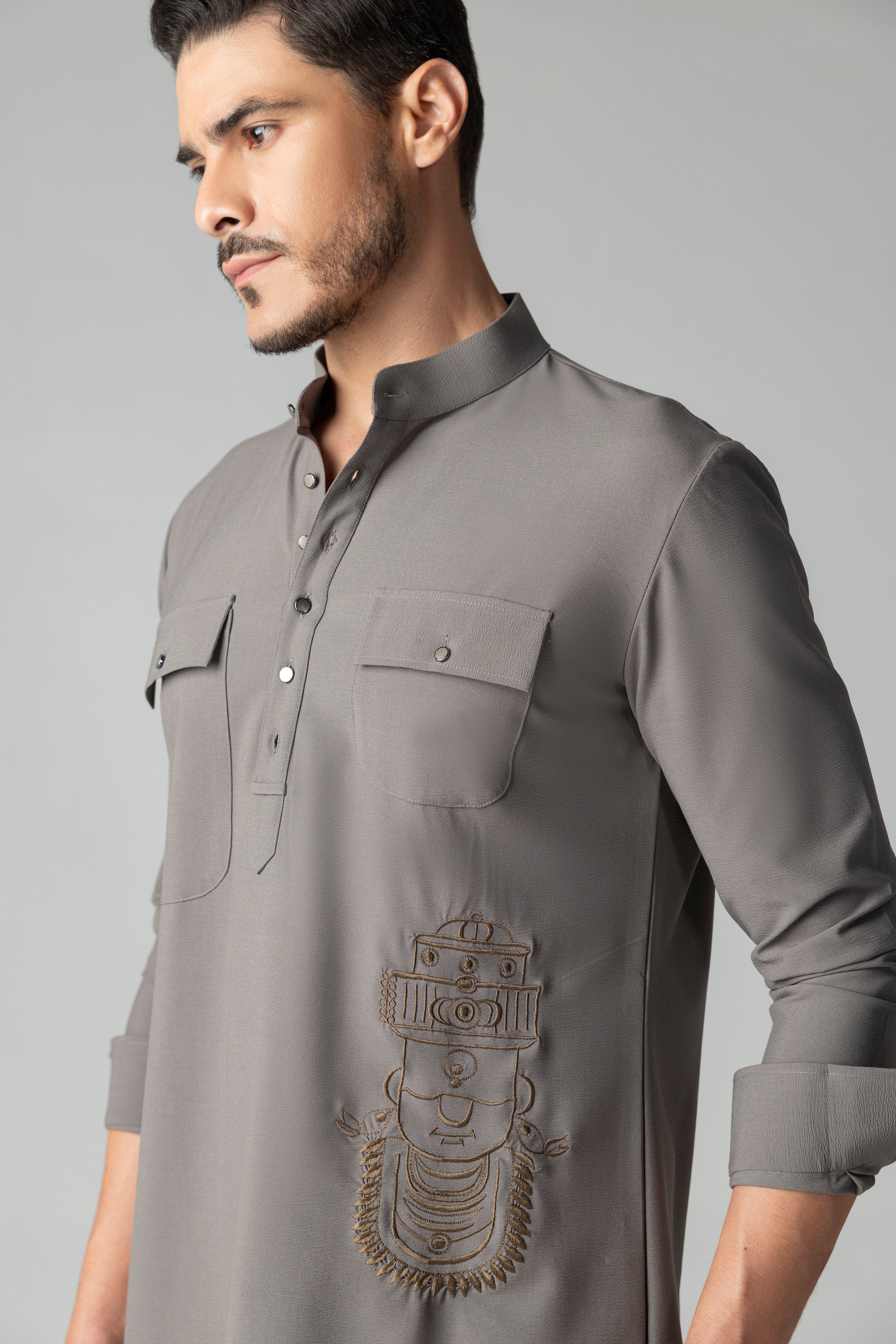Mouse coloured short crepe kurta with thread embroidery on the waist & patch pocket detailing, paired with a matching plazzo