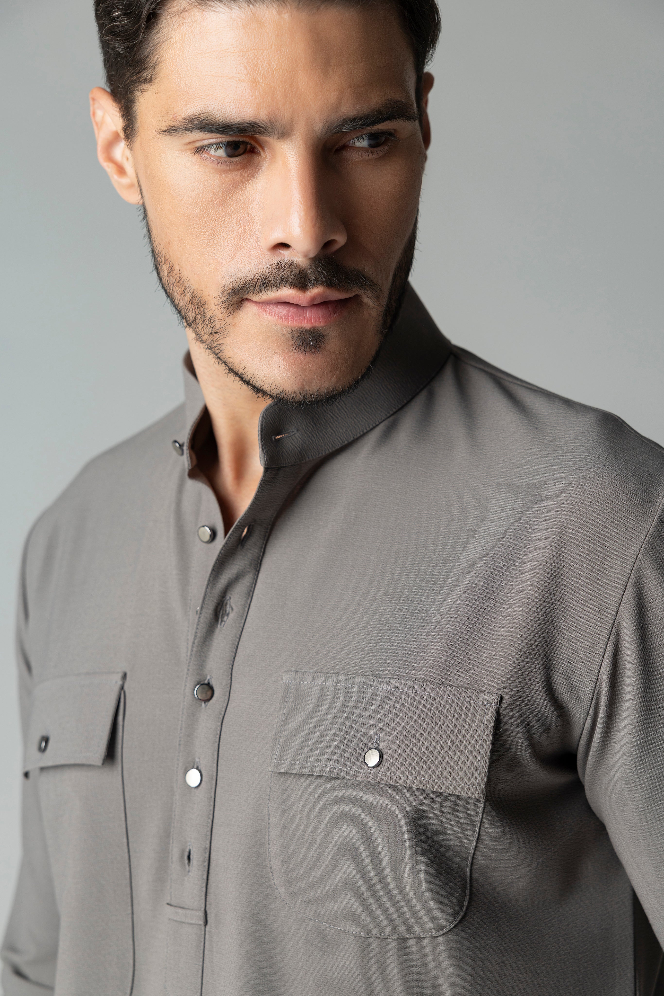 Mouse coloured short crepe kurta with thread embroidery on the waist & patch pocket detailing, paired with a matching plazzo