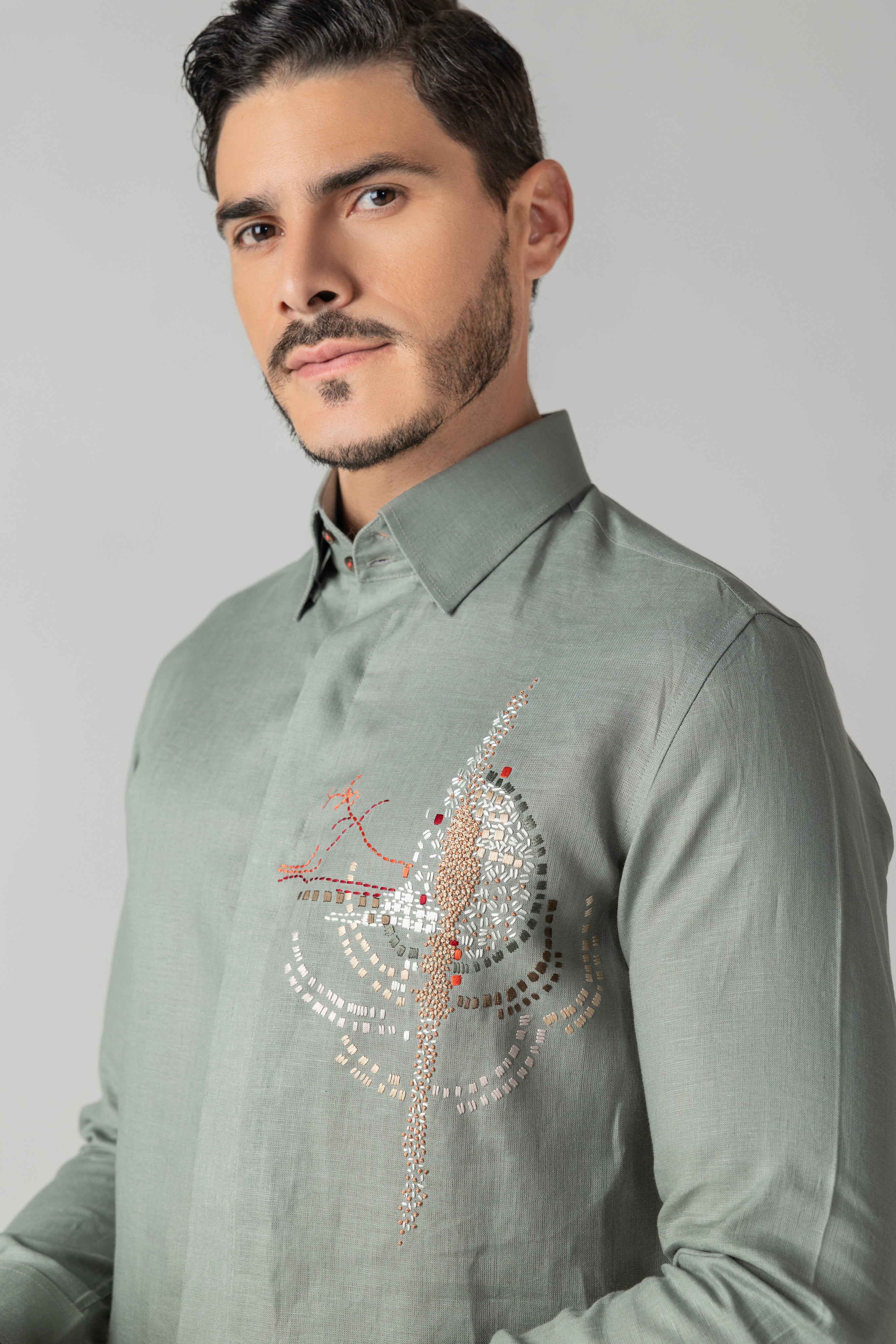 Sage green linen shirt with multi-coloured hand-embroidered motif