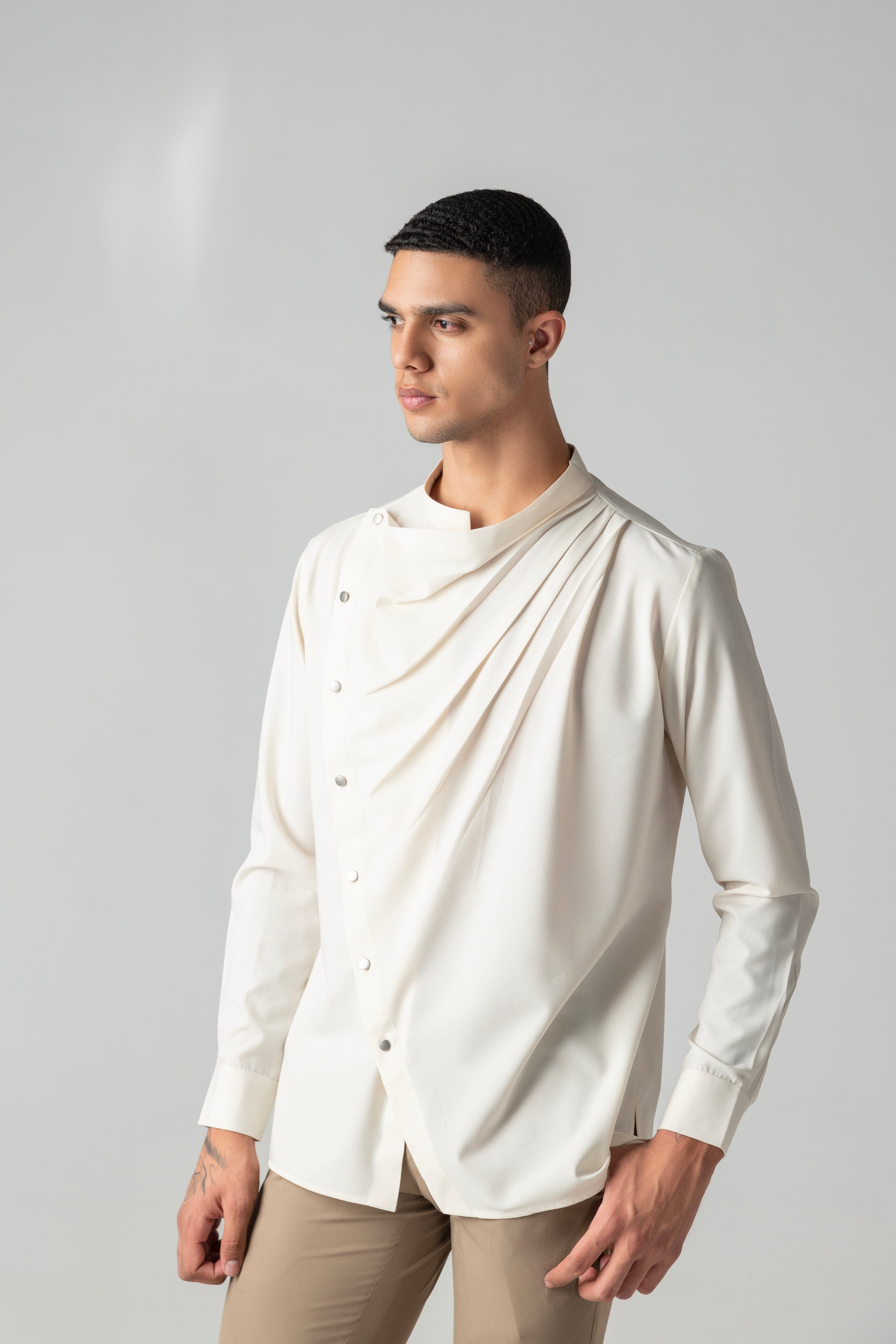 Cream shirt with asymmetrical buttons & drape detailing.