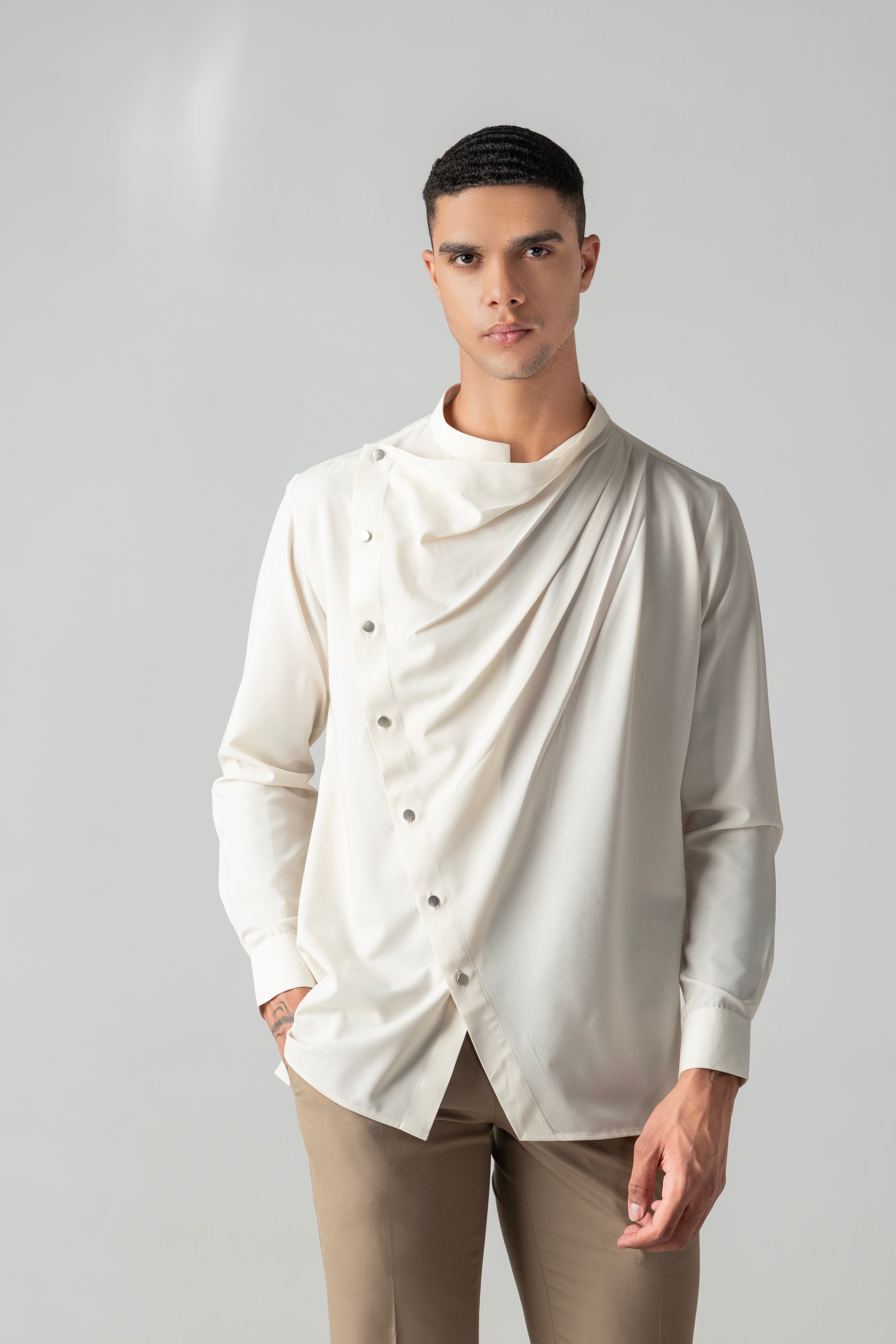 Cream shirt with asymmetrical buttons & drape detailing.
