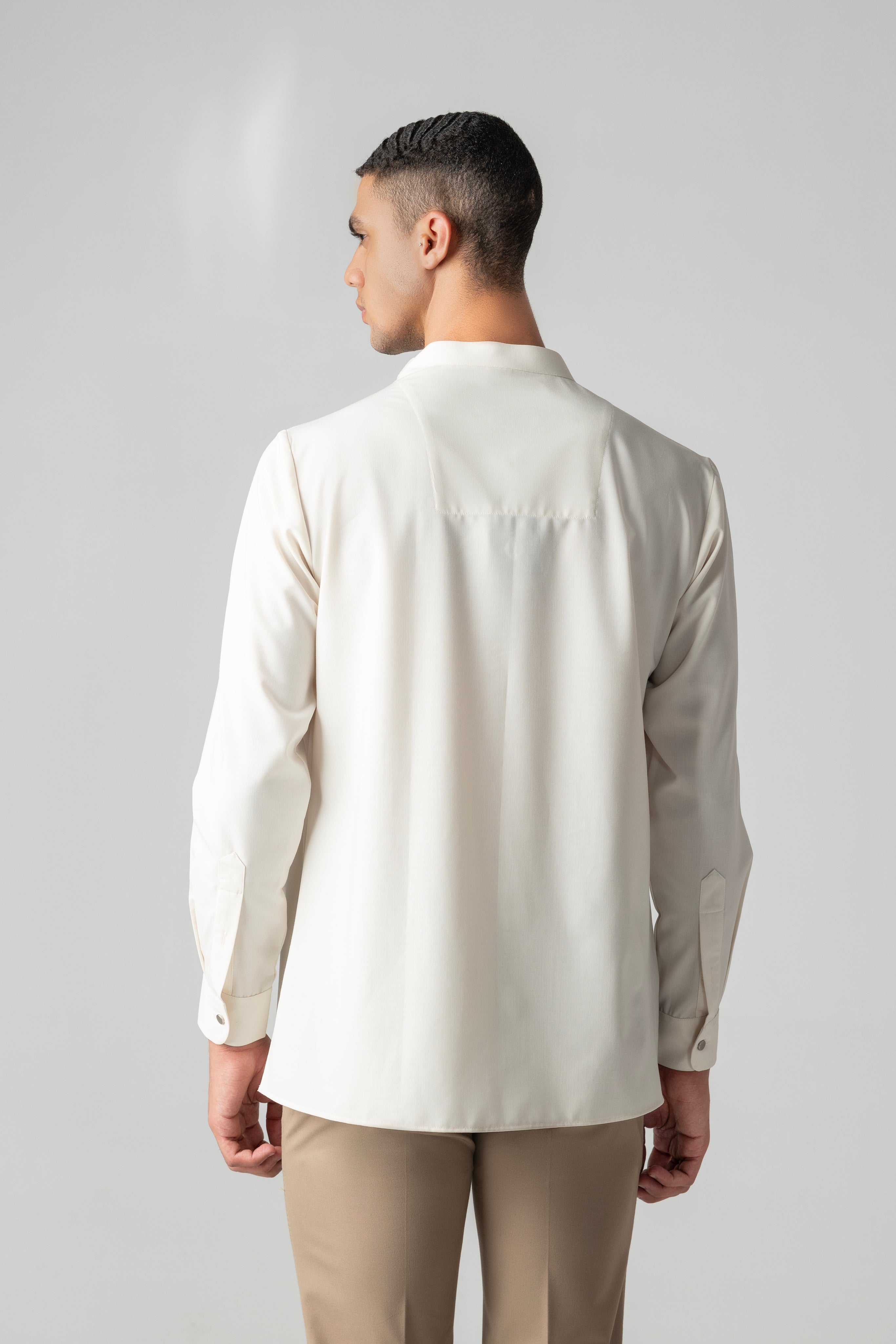Cream shirt with asymmetrical buttons & drape detailing.