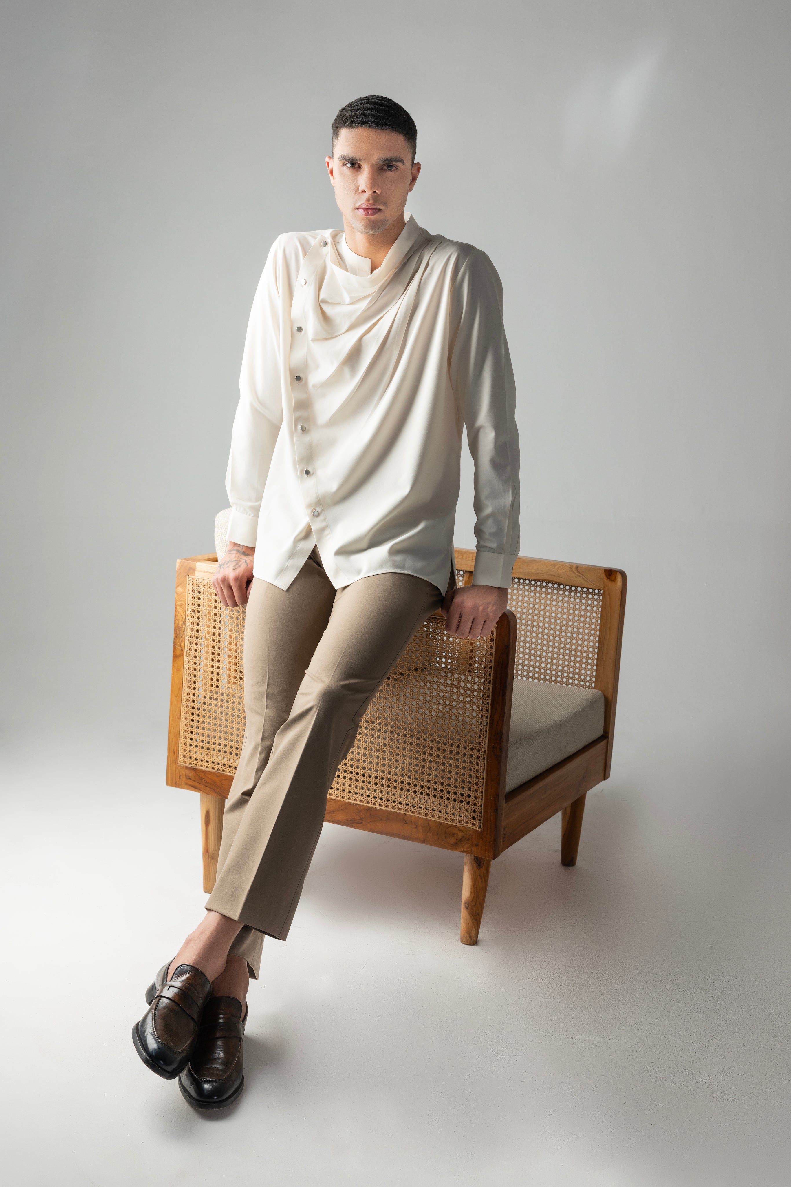Cream shirt with asymmetrical buttons & drape detailing.