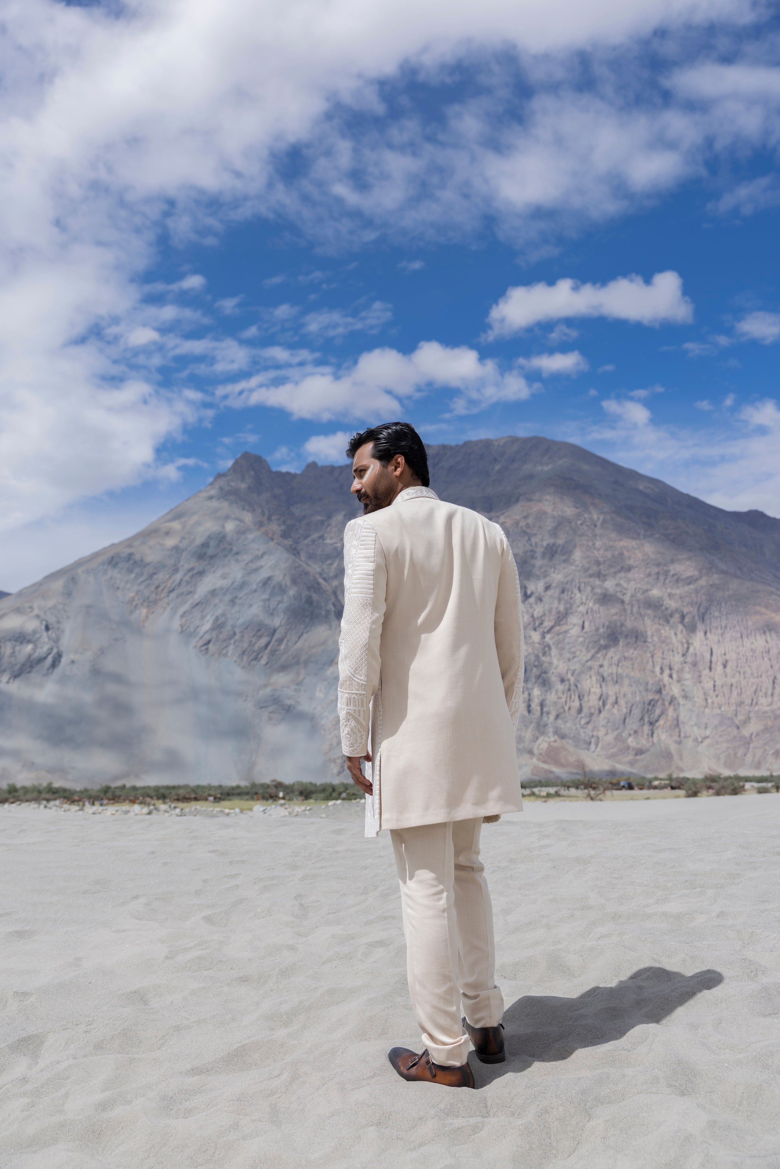 Cream hand-embroidered open long indowestern jacket paired with a short kurta and pants.