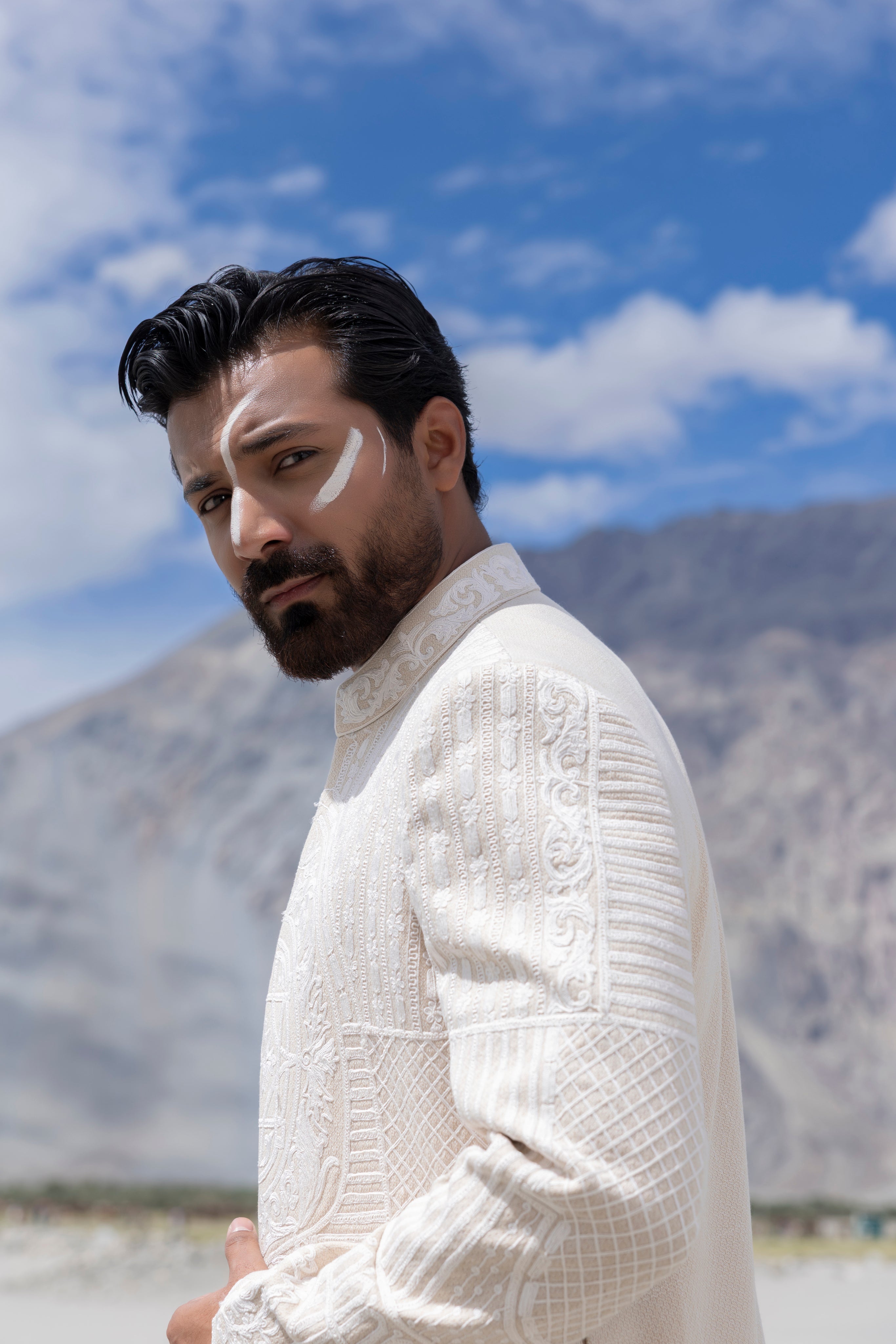 Cream hand-embroidered open long indowestern jacket paired with a short kurta and pants.