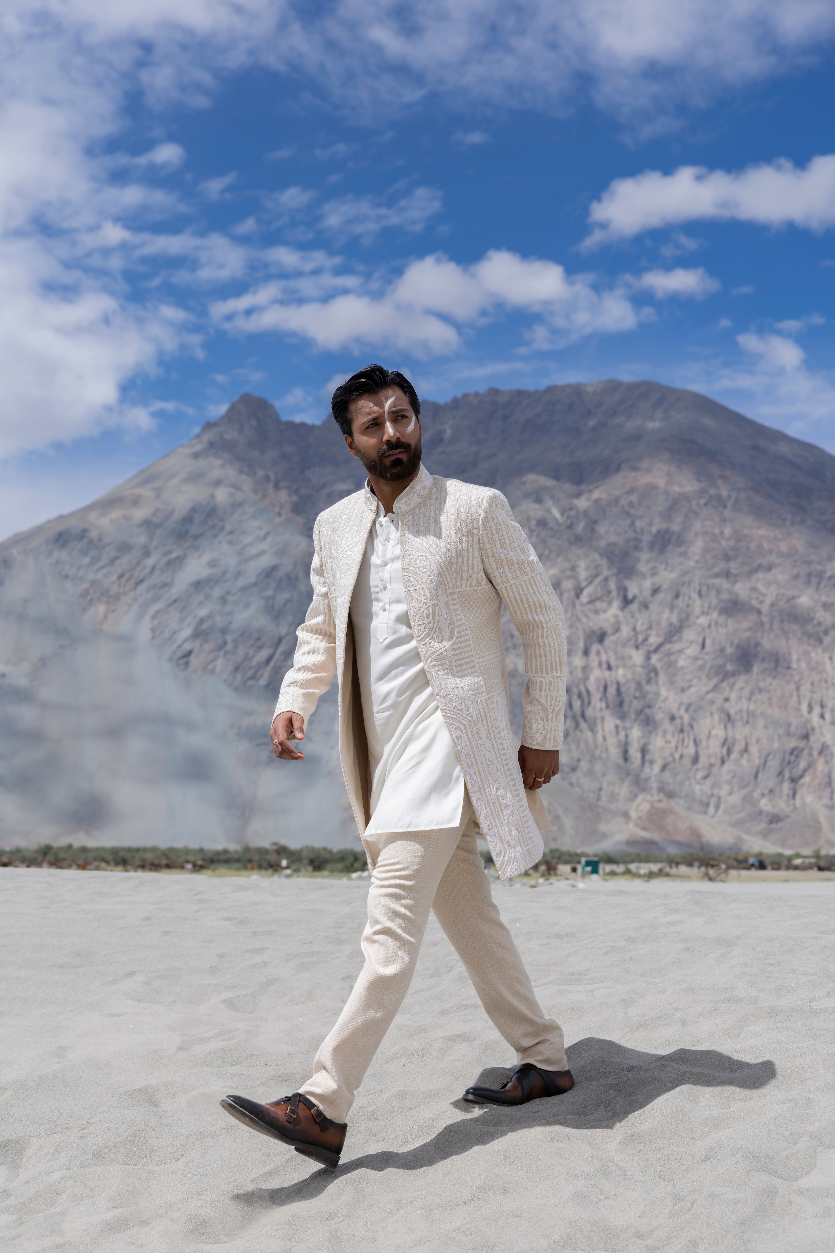 Cream hand-embroidered open long indowestern jacket paired with a short kurta and pants.