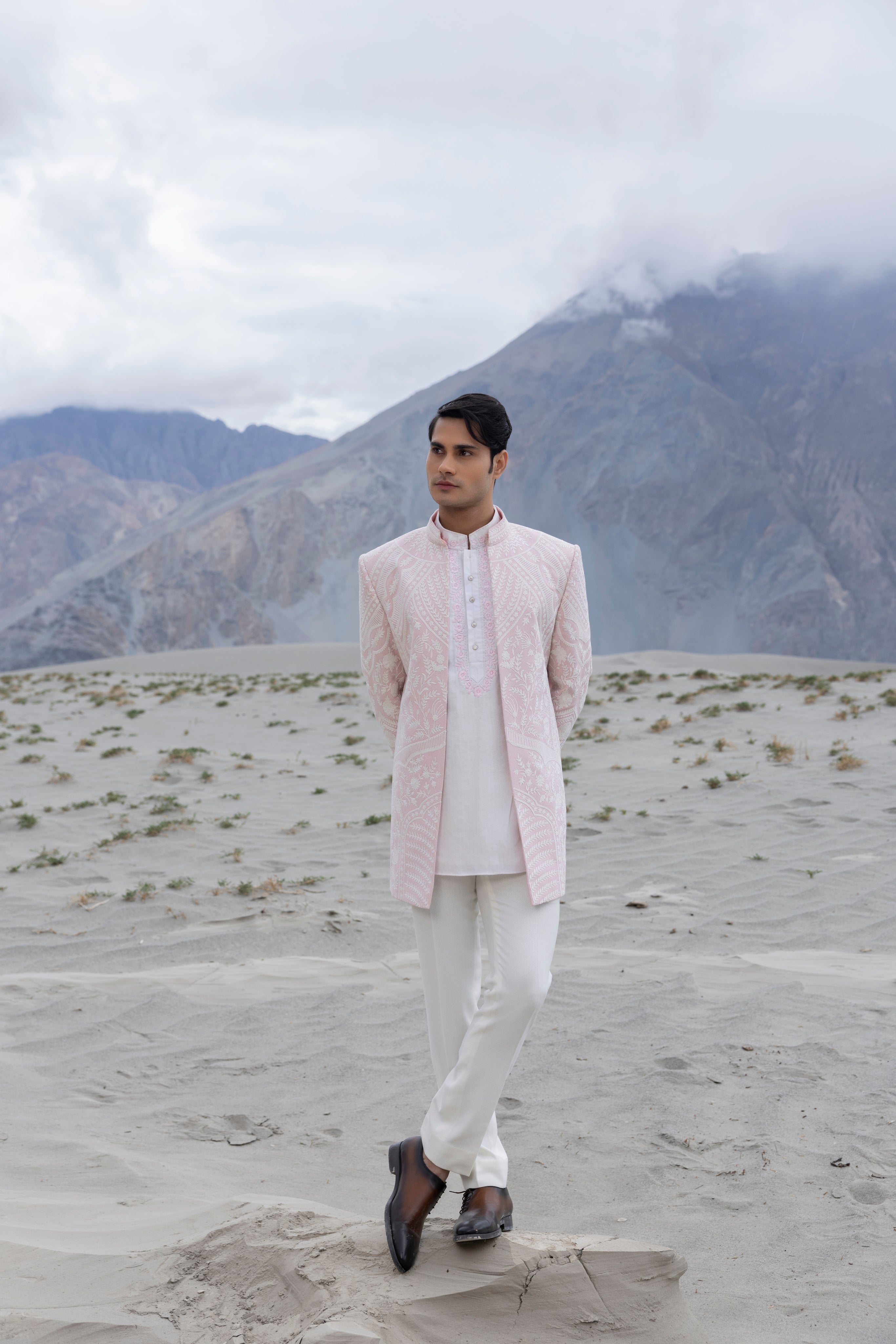 Pink textured knit, front open short indowestern jacket with ivory hand-embroidery paired with an embroidered herringbone silk kurta  and a pant.