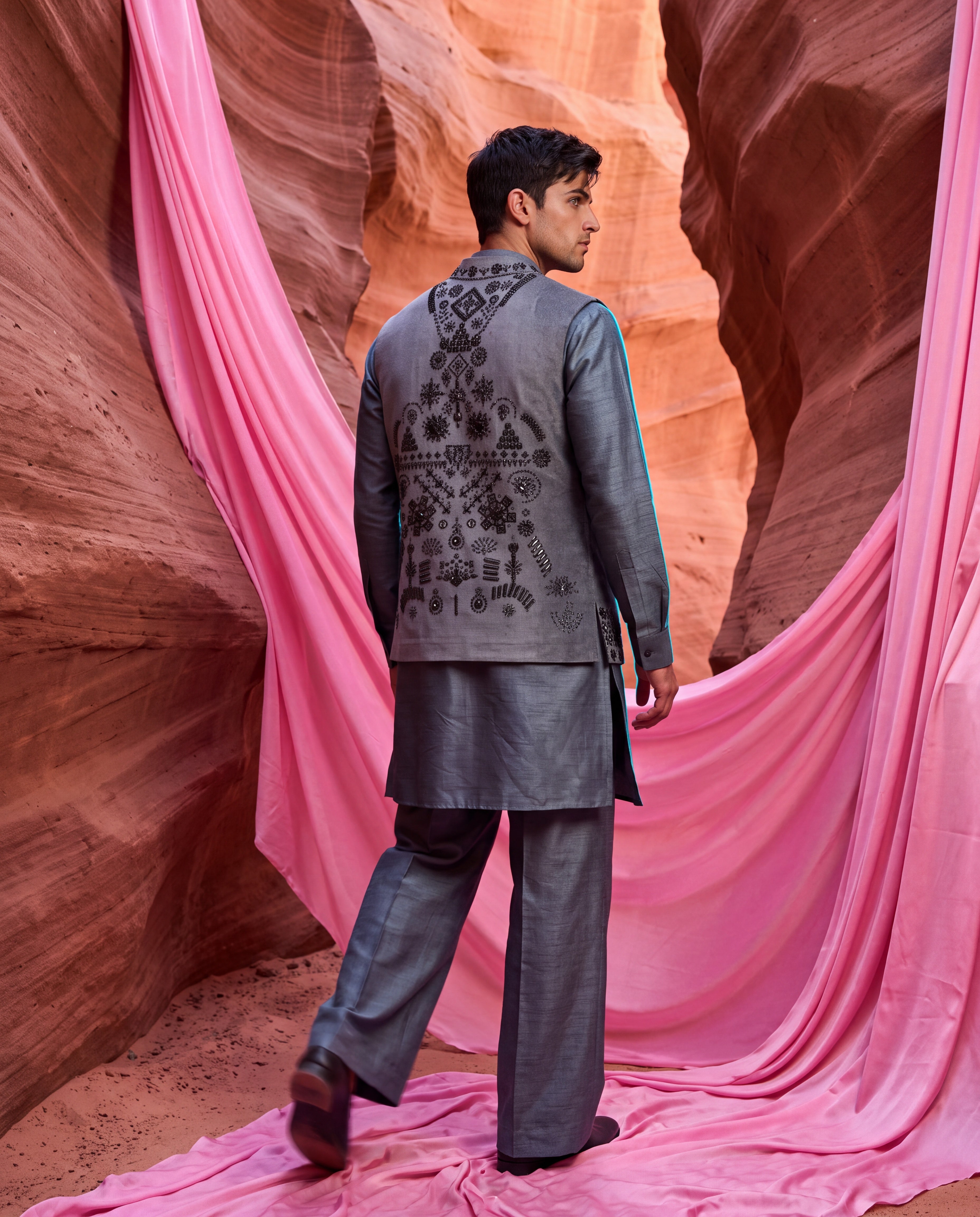 Grey textured velvet waistcoat with metallic hand embroidery detailing, paired with an embroidered silk kurta and matching aligadhi pants.