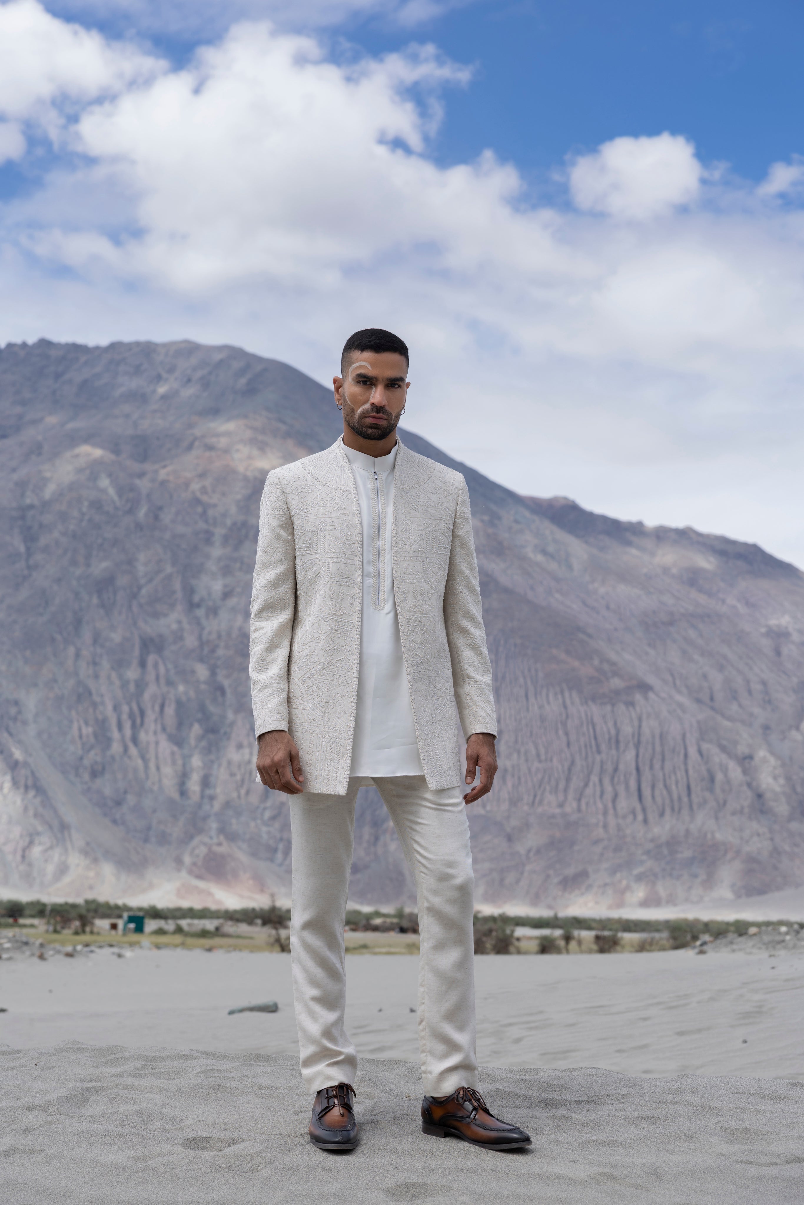 Beige poly linen, front open short indowestern jacket with monotone hand-embroidery paired with an embroidered kurta and a poly linen pant.