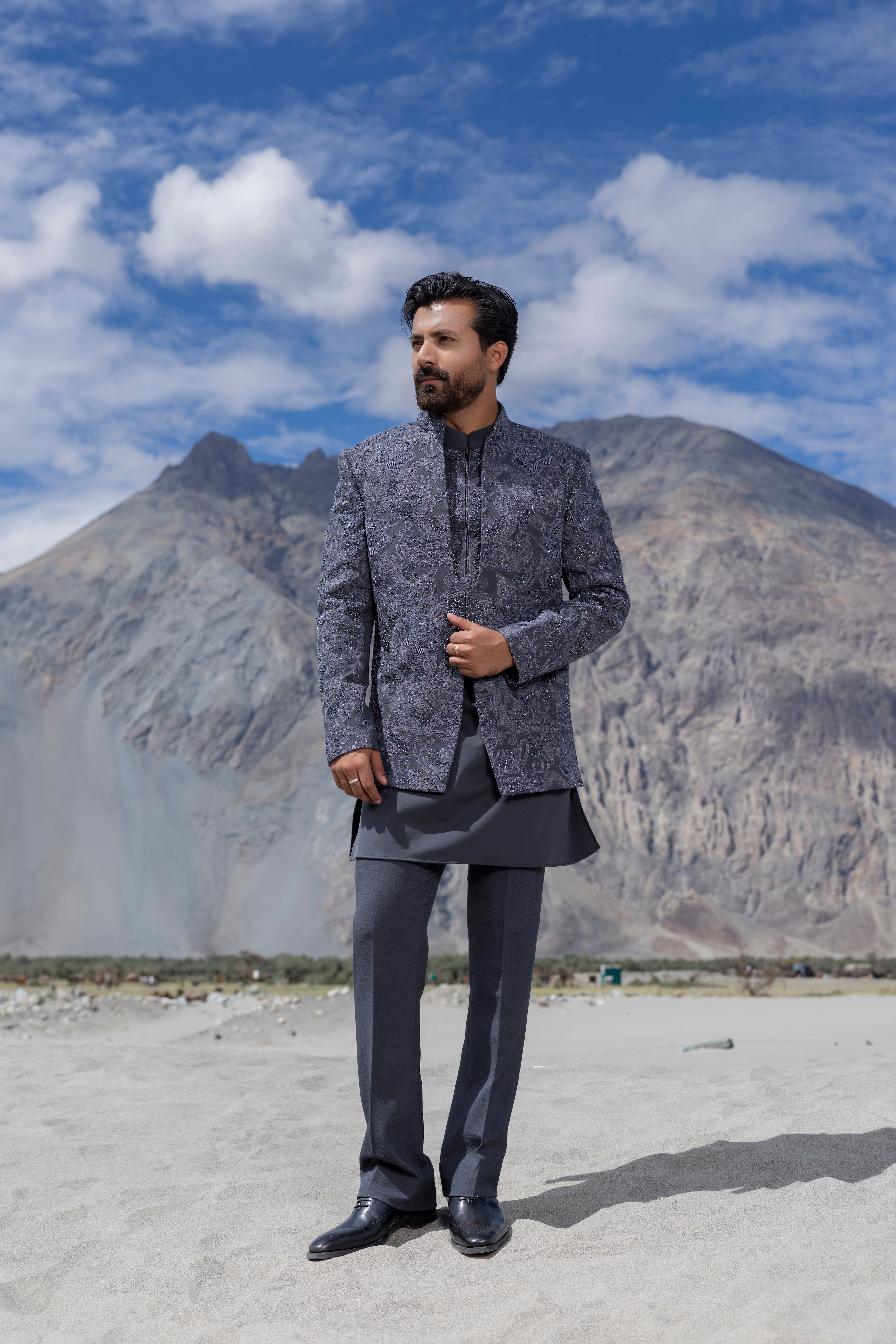 Grey hand-embroidered indowestern jacket paired with an embroidered short kurta and pants.