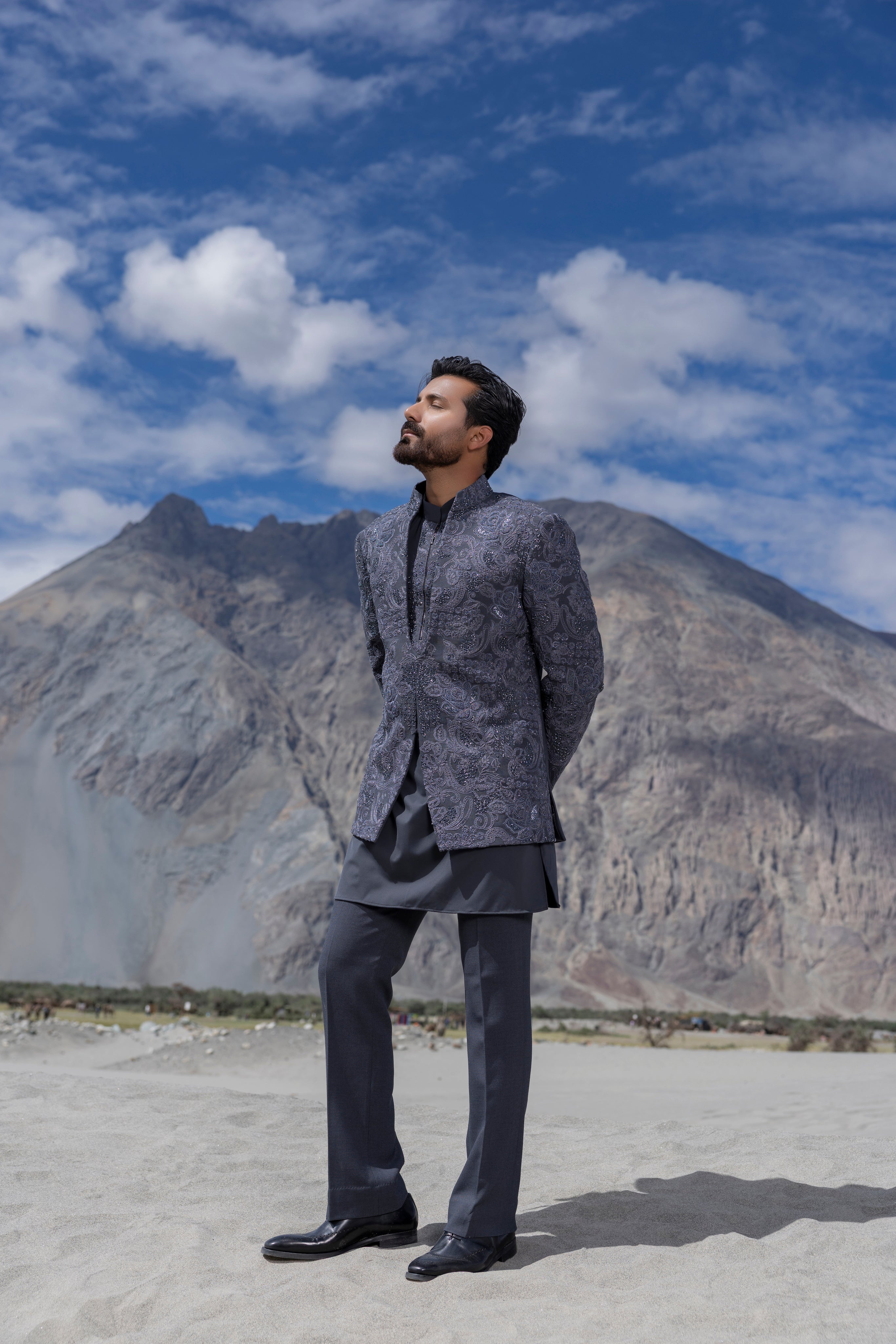 Grey hand-embroidered indowestern jacket paired with an embroidered short kurta and pants.
