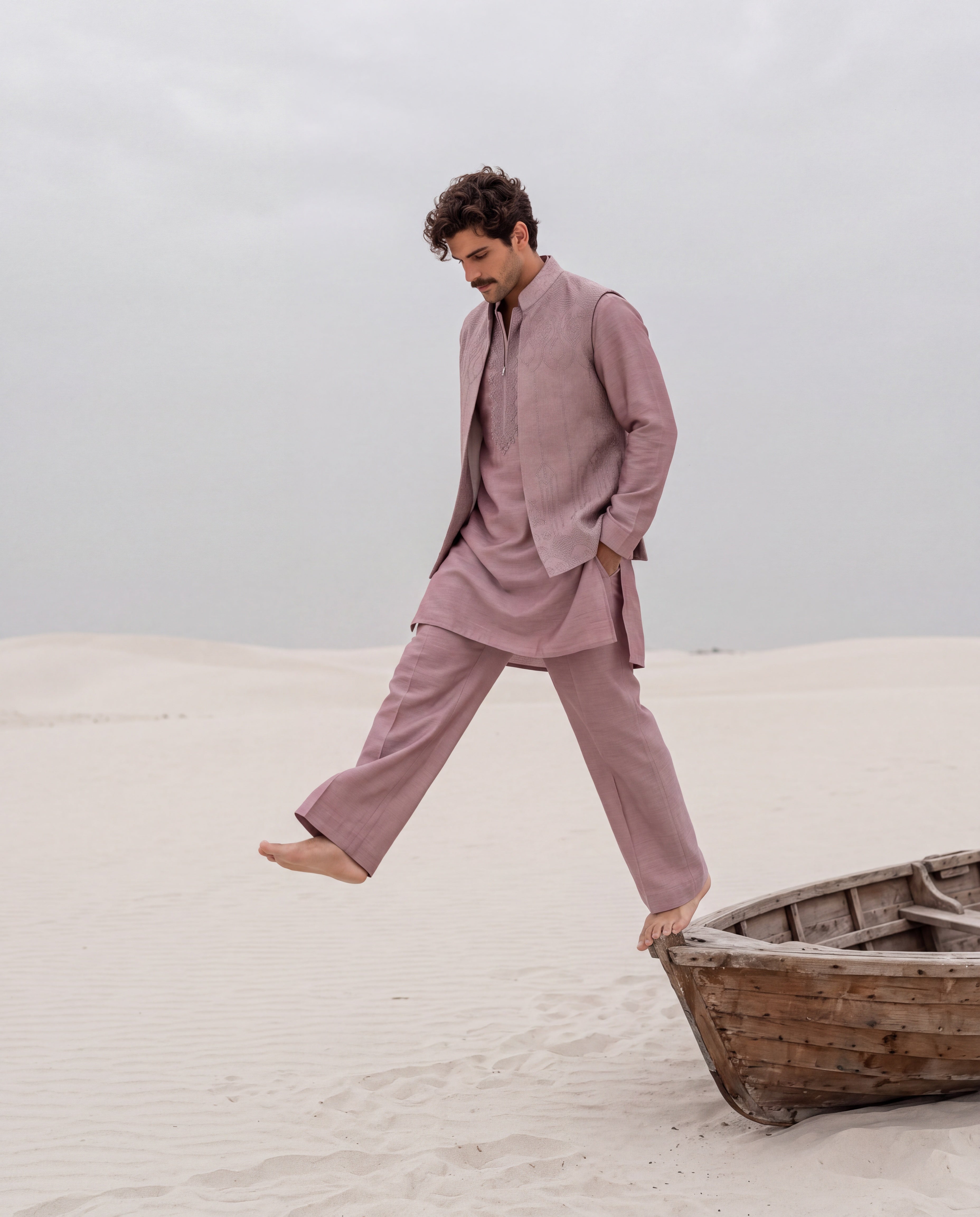 Mauve textured velevet waistcoat with monotone hand embroidery detailing, paired with an embroidered silk kurta and matching aligadhi pants.