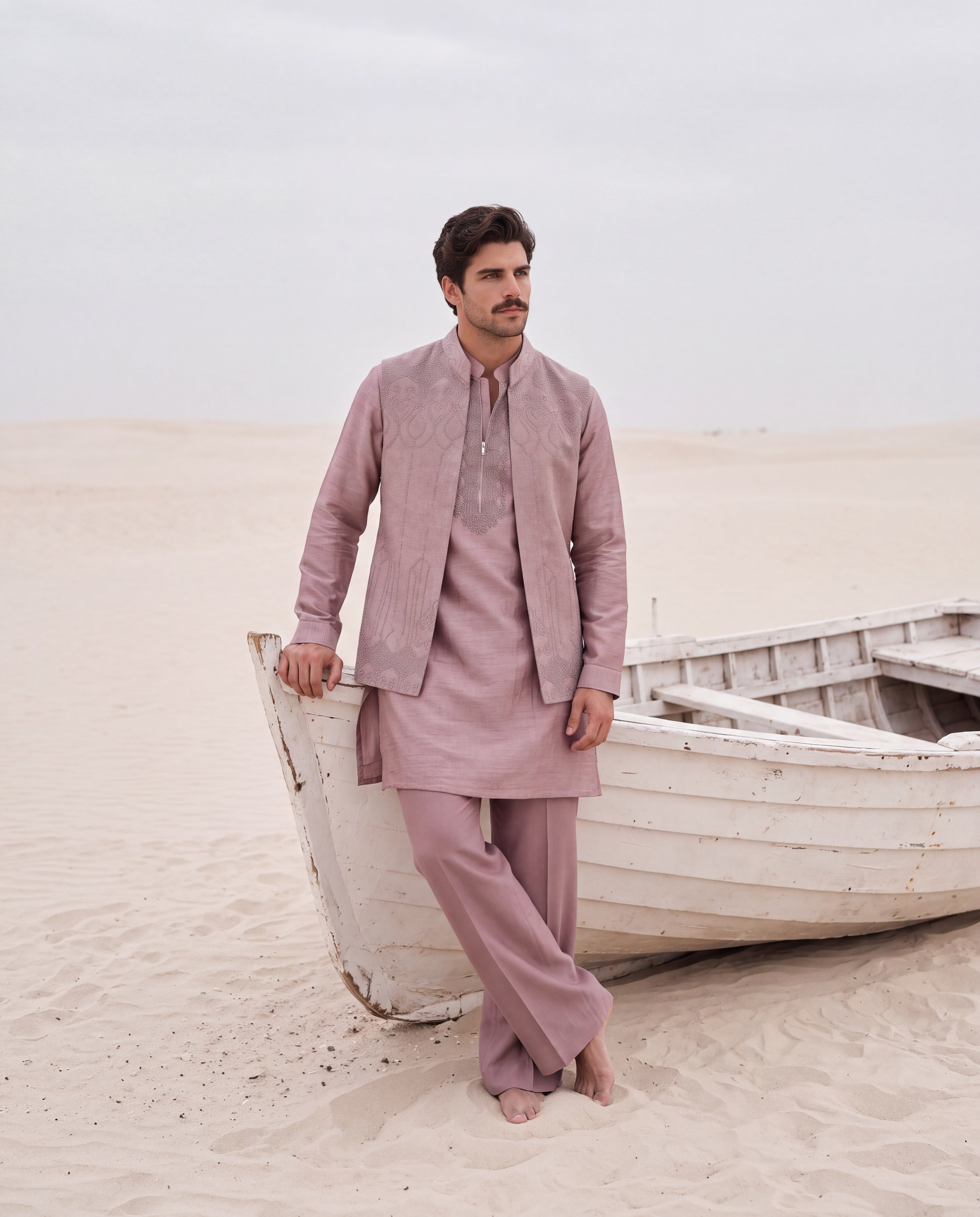 Mauve textured velevet waistcoat with monotone hand embroidery detailing, paired with an embroidered silk kurta and matching aligadhi pants.