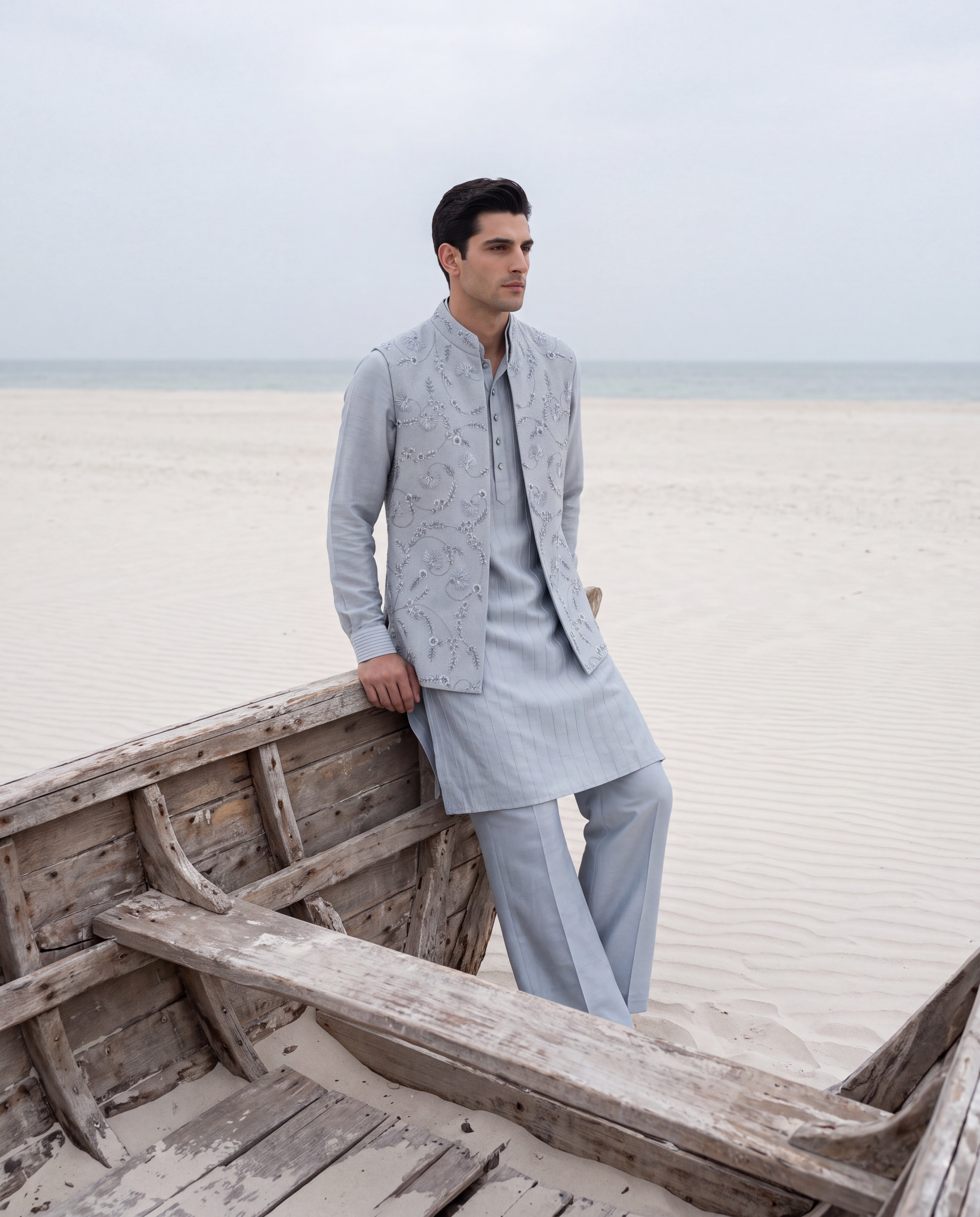 Sky blue herringbone waistcoat with monotone hand embroidery detailing, paired with a matching striped kurta and aligadhi pants.
