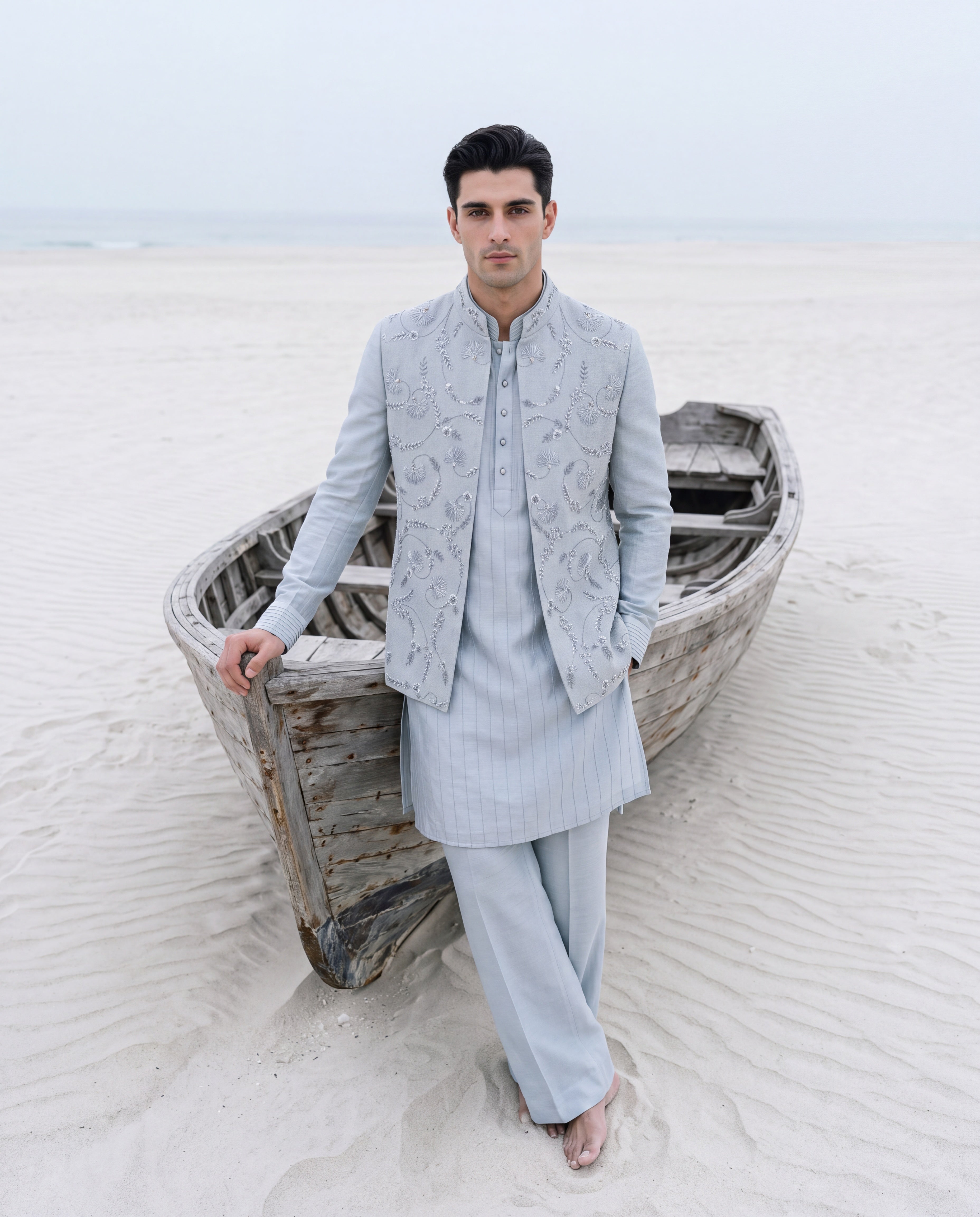 Sky blue herringbone waistcoat with monotone hand embroidery detailing, paired with a matching striped kurta and aligadhi pants.