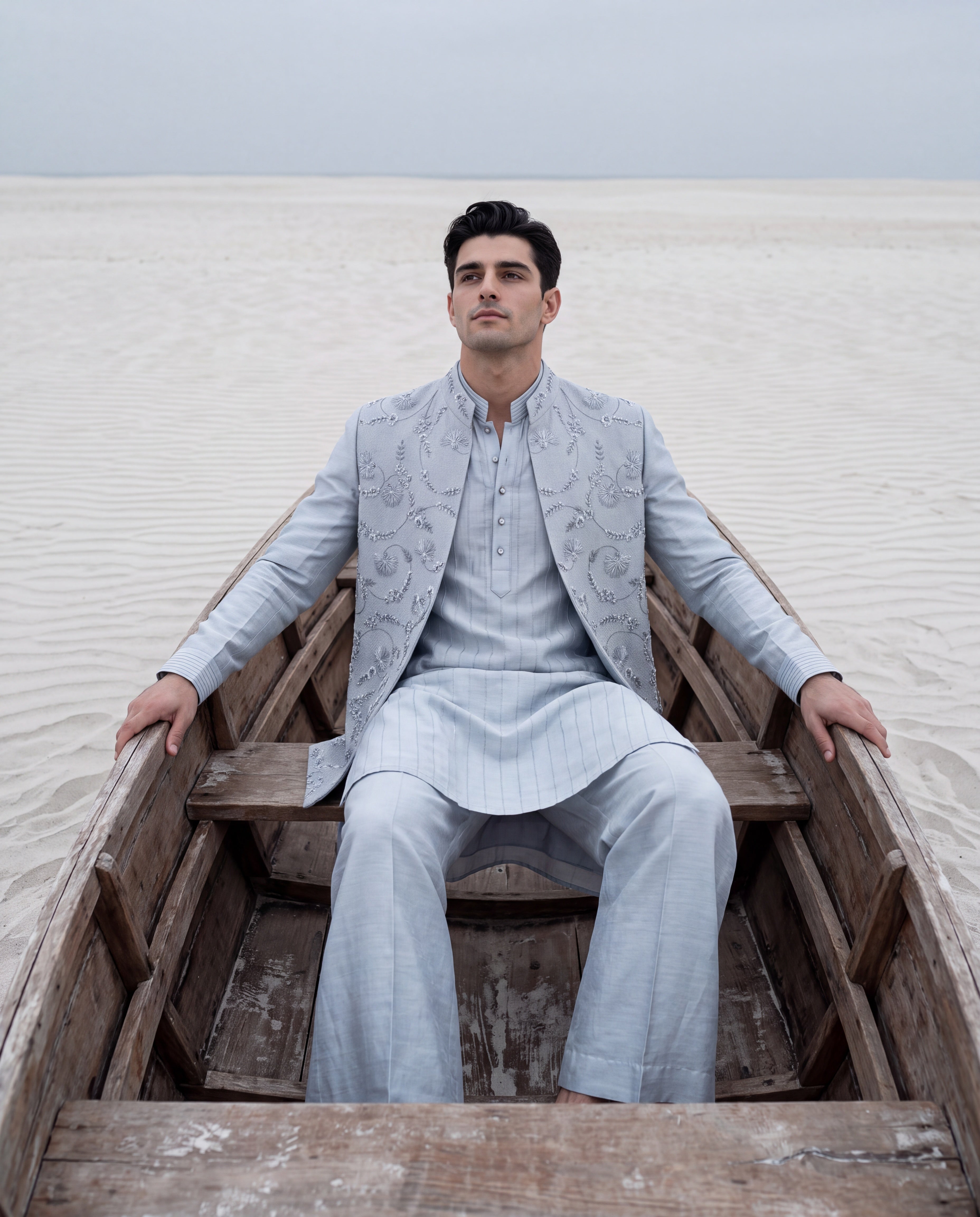 Sky blue herringbone waistcoat with monotone hand embroidery detailing, paired with a matching striped kurta and aligadhi pants.