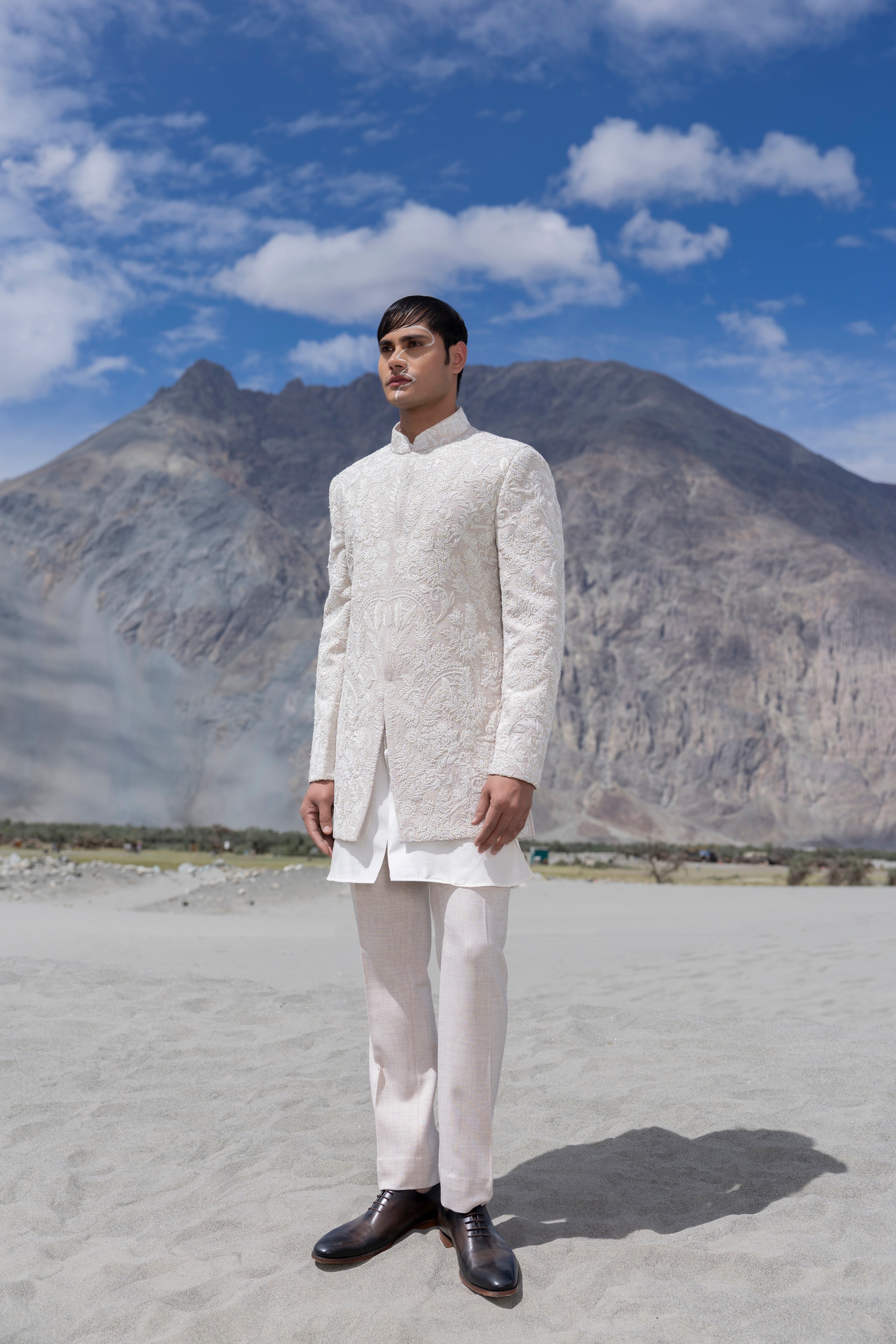 Baby pink hand-embroidered indowestern paired with a short ivory kurta and matching pants.